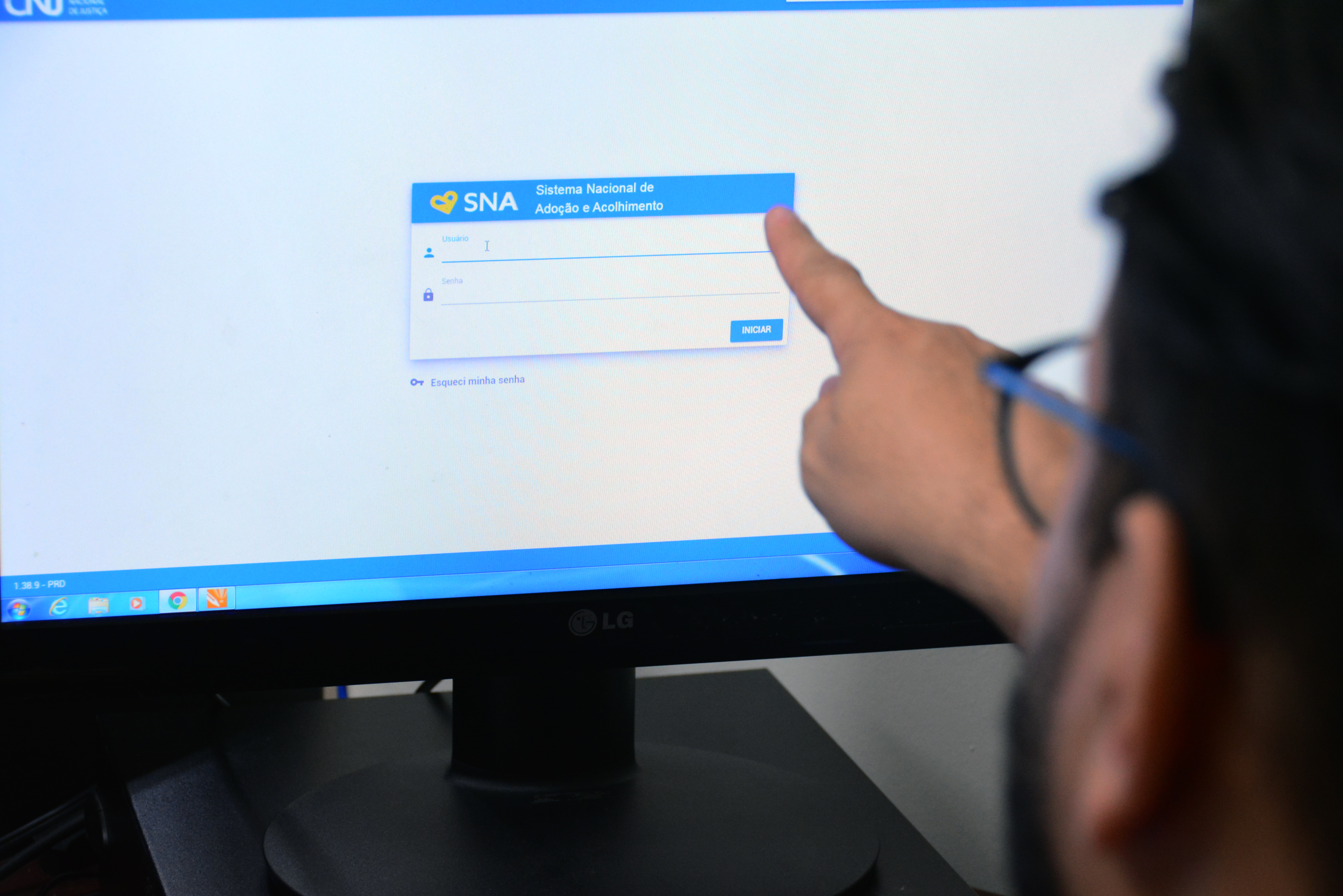 Uma pessoa acessando o Sistema Nacional Adoção no computador.  