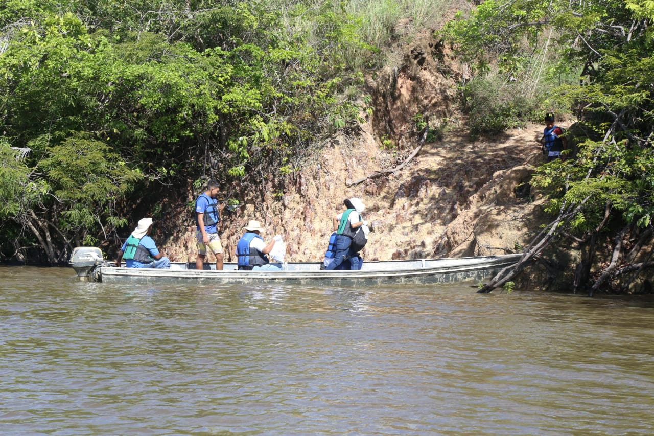 Pessoas dentro de um barco, ajudando na limpeza do rio Branco
