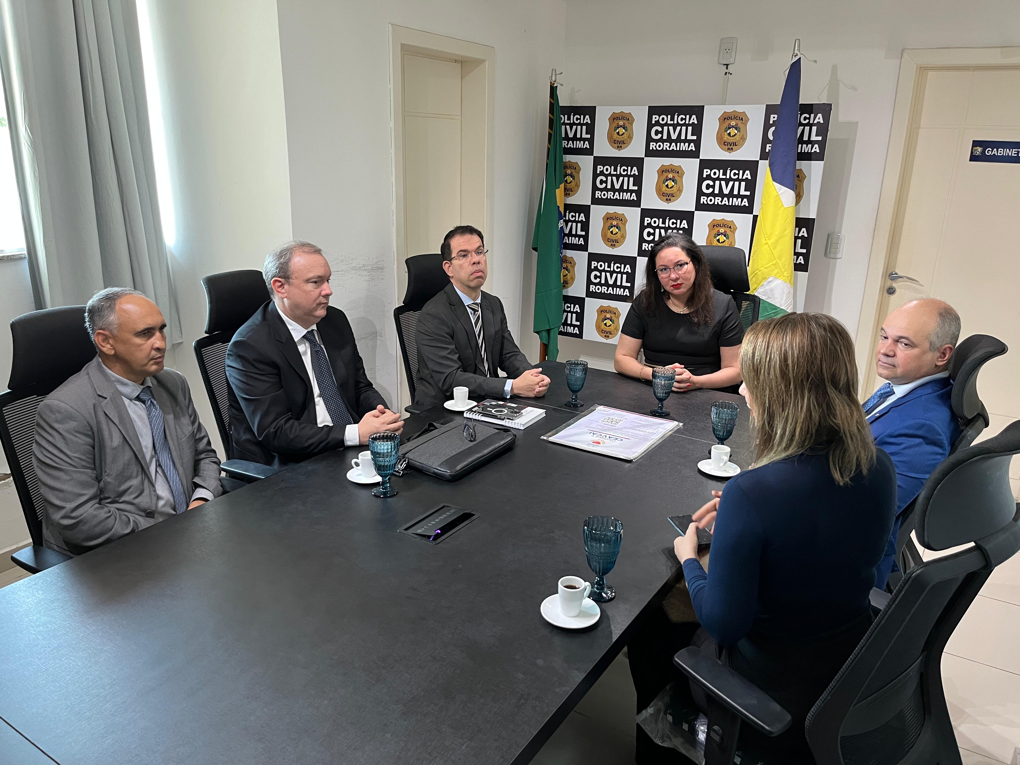 Foto colorida mostrando o juiz Eduardo Carvalho e a servidora Laura Cabral durante reunião na Polícia Civil