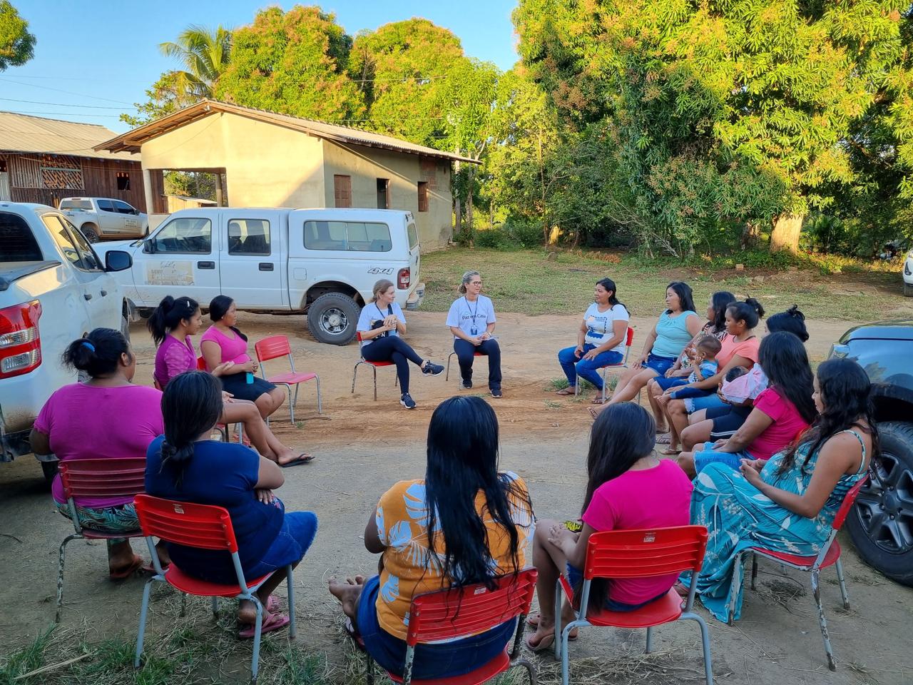 Foto colorida mostra quinze pessoas em um círculo de roda de conversa