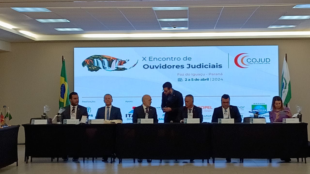 Imagem colorida mostra mesa com palestrantes sentados durante o Décimo Encontro de Ouvidores Judiciais do Brasil.