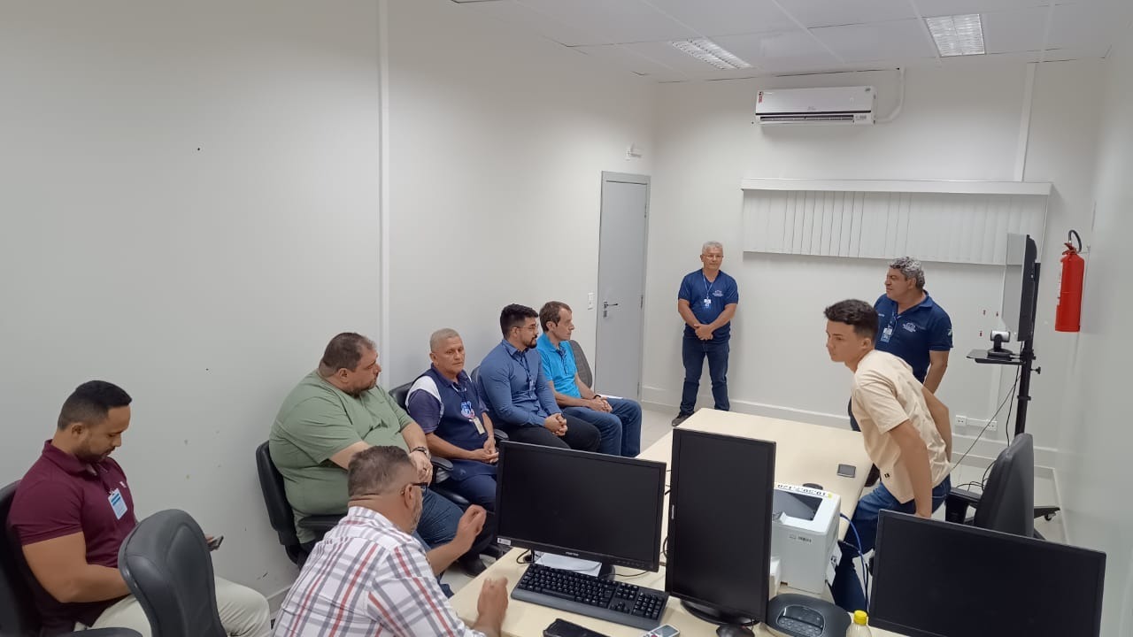Foto colorida mostra nove pessoas conversando em uma sala duarnte uma visita técnica