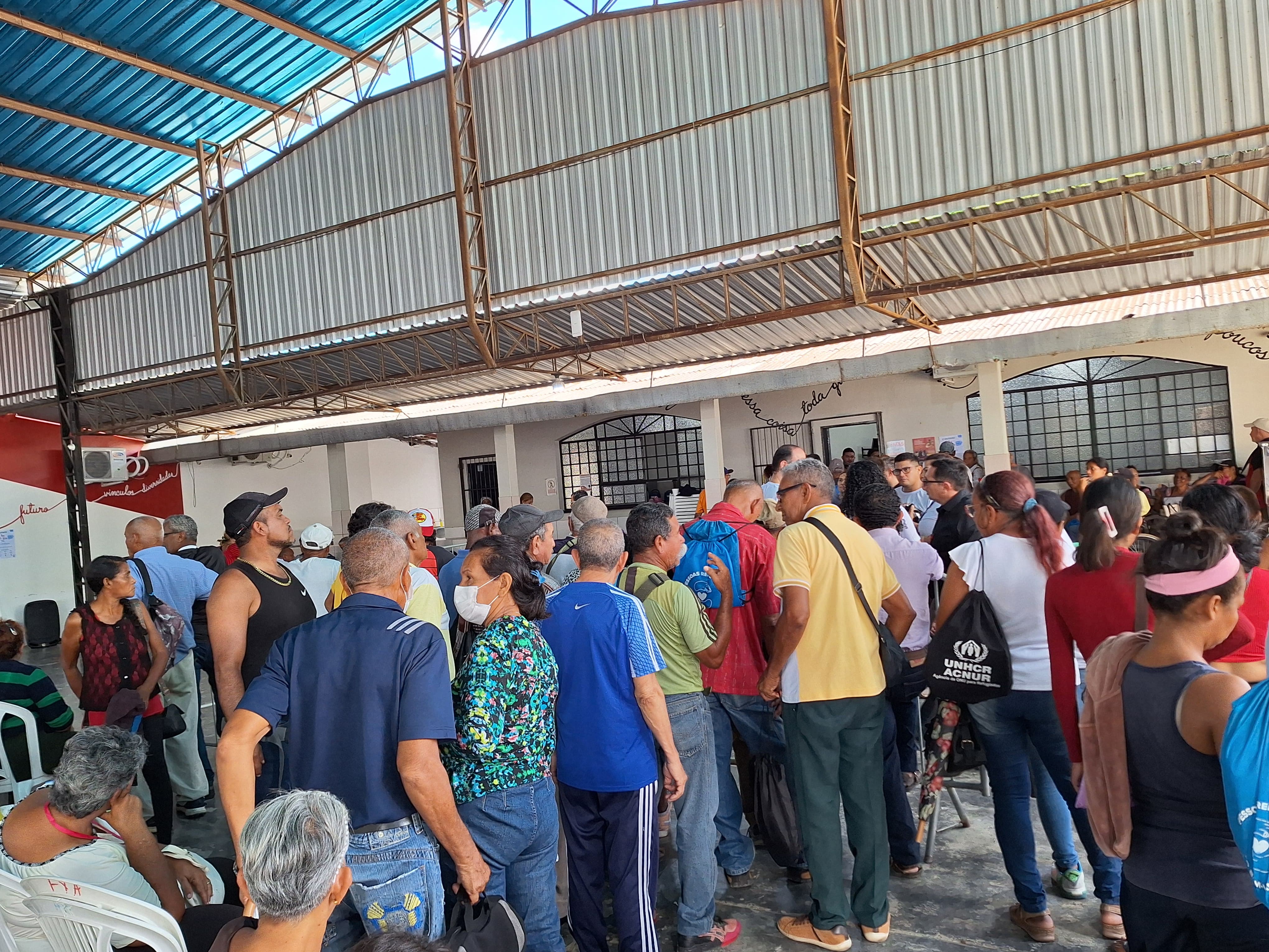  foto colorida de pessoas na fila de atendimento