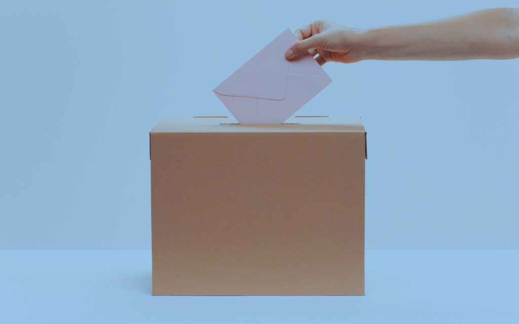 Uma pessoa colocando uma carta em uma caixa 