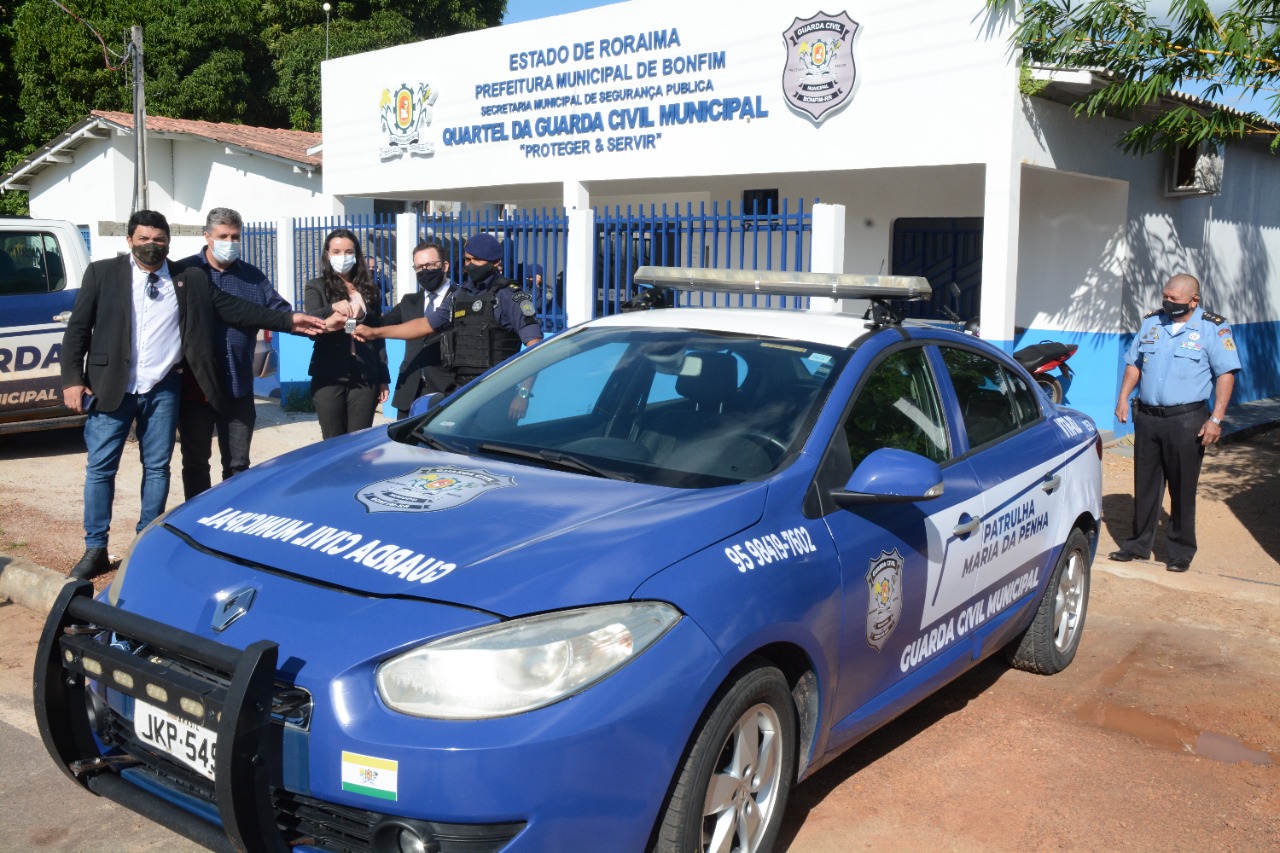 Foto dos juízes do TJRR com o prefeito de Bonfim em frente ao carro da patrulha Maria da Penha no município