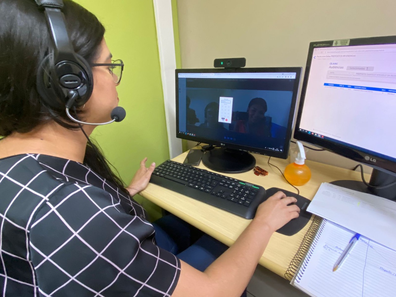 Uma mulher sentada em frente a um computador durante uma reunião online 