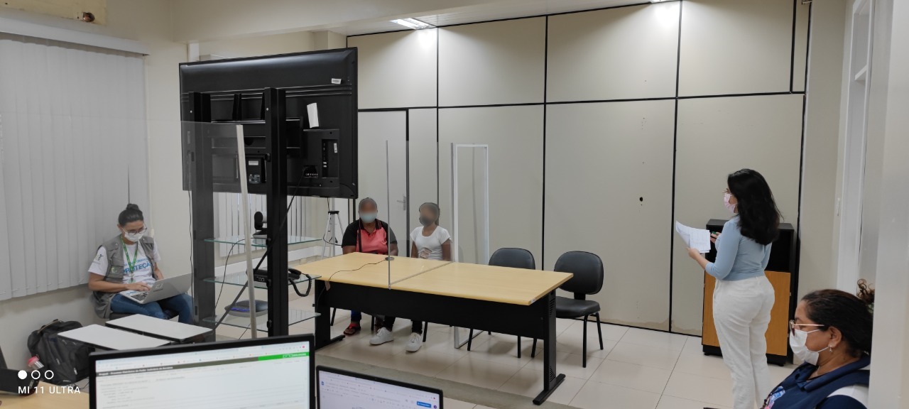 Imagem colorida contém quatro mulheres e uma menina em uma sala branca durante mutirão de audiência para regulamentação da guarda de crianças e adolescentes, da 1ª e 2ª Vara da Infância e Juventude do TJRR.