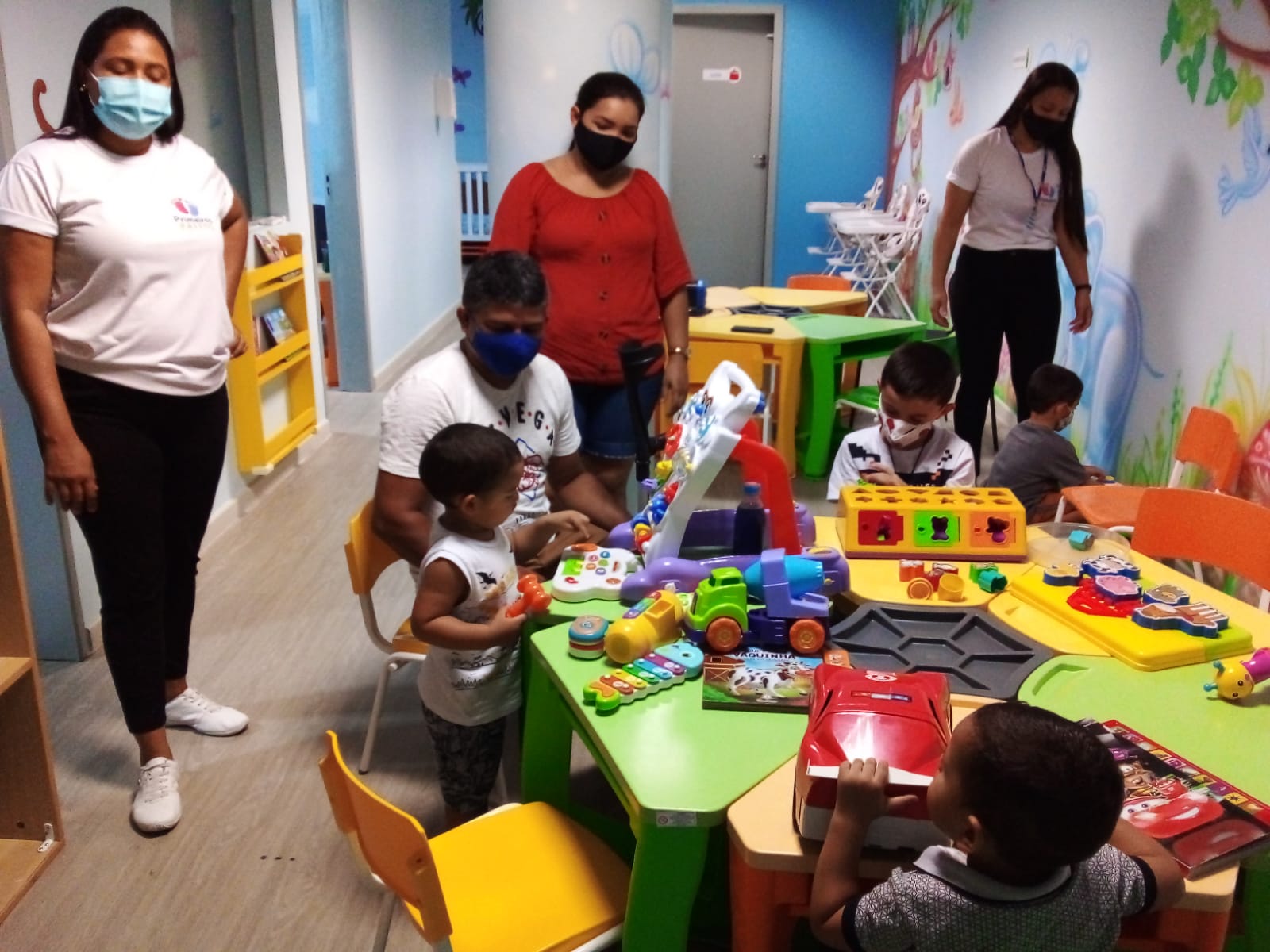 colorida que contém pais, filhos e servidoras do TJRR durante oficina de assessoria do Programa Primeiro Passos.