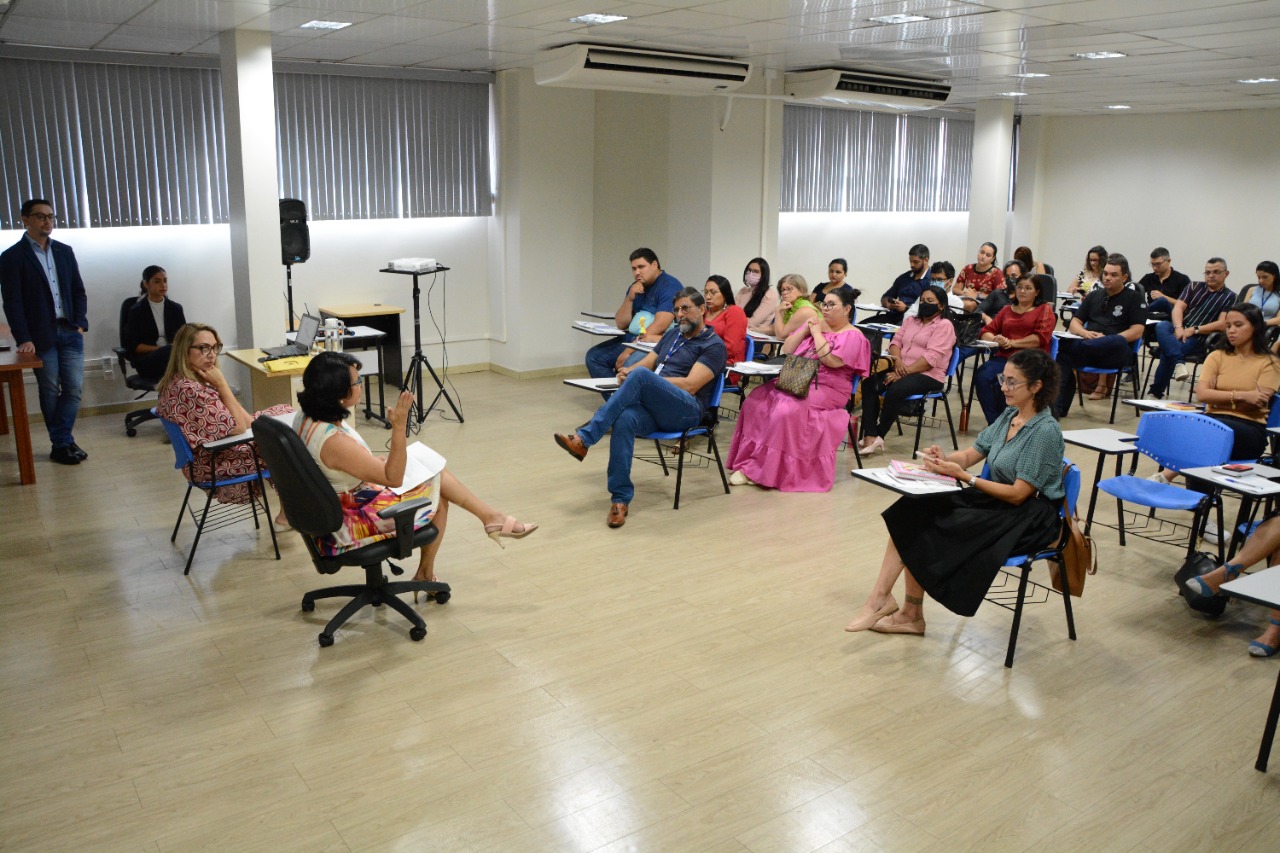 foto colorida mostra a sala com as equipes multiprofissionais atuantes no atendimento à pessoa custodiada, aos reeducandos em cumprimento de penas alternativas, pré-egressos e egressos do sistema prisional, participando do curso de capacitação da GMF.