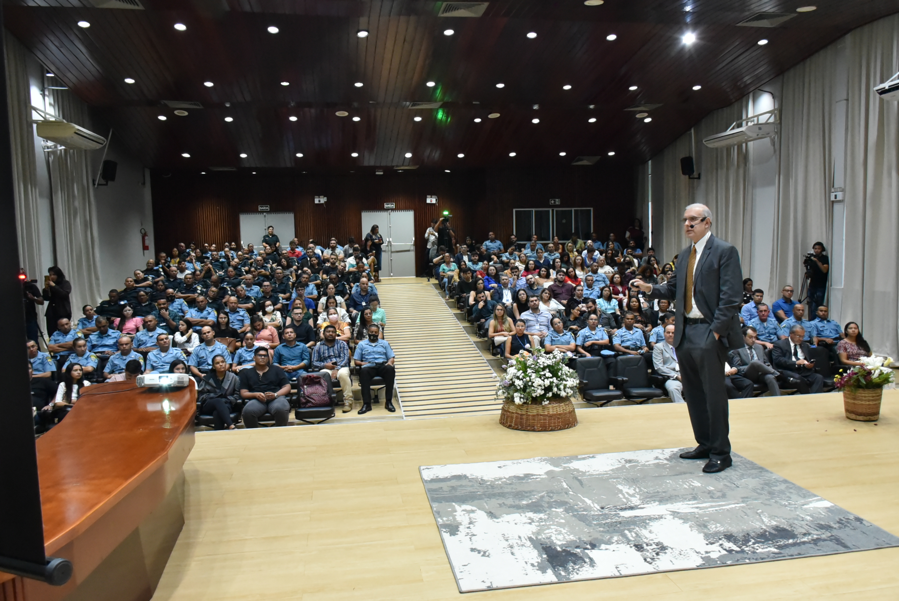 Imagem colorida em formato retangular mostra um grande público no auditório do Fórum Cível Advogado Sobral Pinto, à frente do público está o palestrante, José Barroso Filho, ministro do Superior Tribunal Militar (STM).