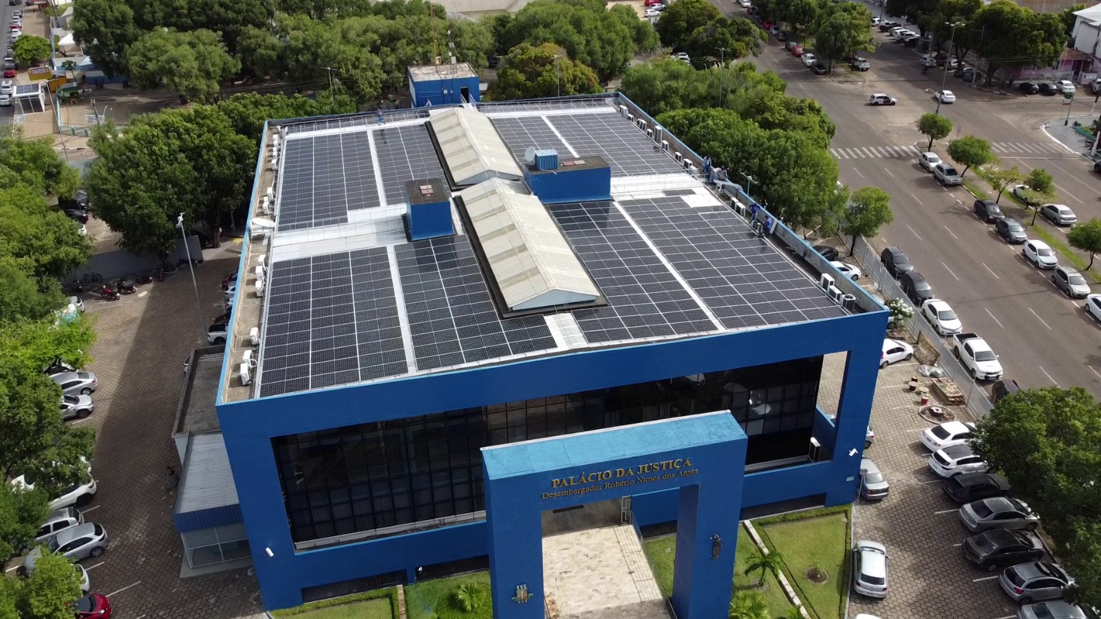 Imagem aérea colorida em formato retangular mostra o teto do Palácio da Justiça  com as placas de energia solar instaladas.