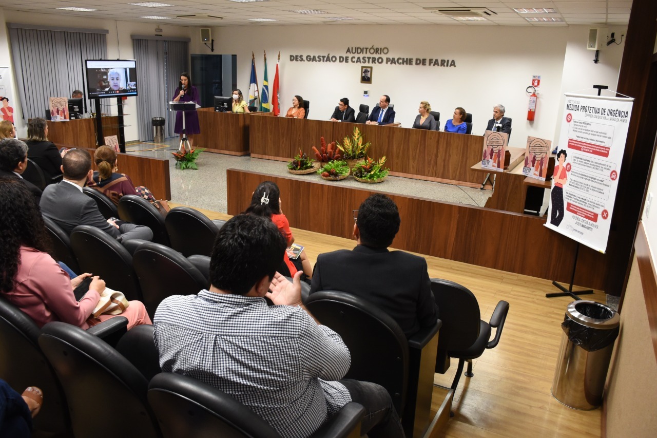 Imagem colorida mostra o auditório de desembargador gastão de castro pache de farias, ocupados por servidores, servidoras, magistrados e magistradas do Poder Judiciário de roraima, à frente estar a mesa de autoridade ocupados por magistrados.