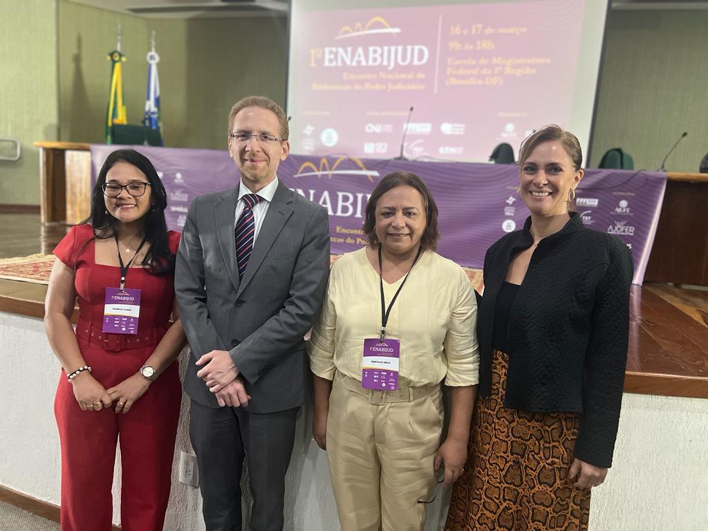 Imagem colorida mostra As servidoras e bibliotecárias Madrice Cunha e Maryluci Melo acompanhadas do juiz Carlos Alexandre Böttcher do TJSP, membro do Comitê do Proname/CNJ e coordenador da Rede BIBLIOMEMOJUS; e da bibliotecária Marília Mello, analista judiciária do TRF-1 e coordenadora do GT 7.