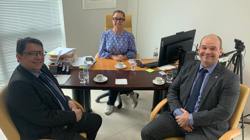 Imagem colorida mostra o presidente do Tribunal de Justiça de Roraima (TJRR), desembargador Jésus Nascimento acompanhado do juiz Eduardo Álvares de Carvalho, coordenador Natjus e do Comitê Estadual de Saúde a frente de uma mesa sentados em lados opostos olhando para câmera. no centro atrás da mesa , também olhando para a foto está a presidente do Conselho Regional de Medicina em Roraima (CRM), Blenda Avelino Garcia.