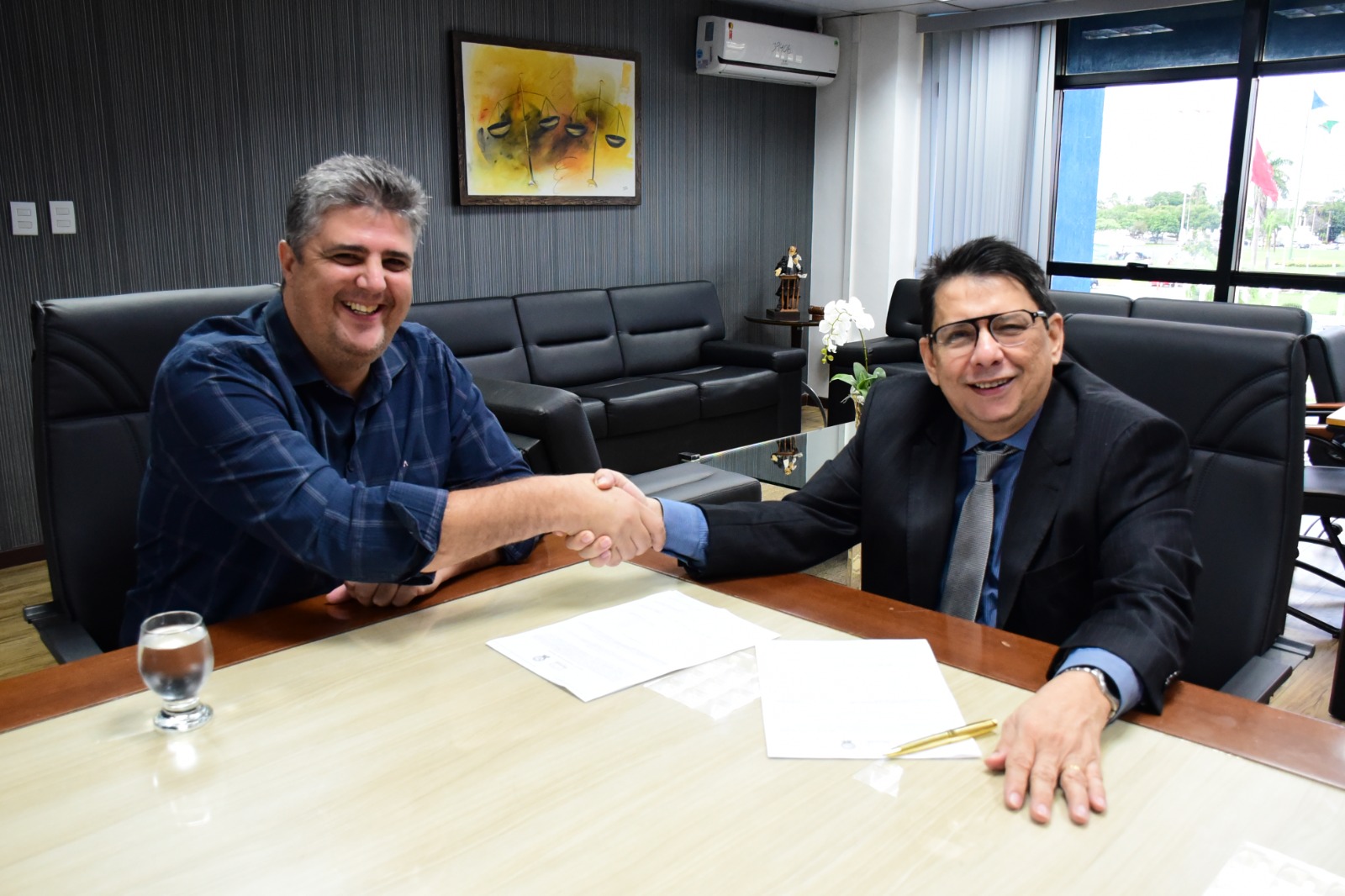 foto colorida do presidente do TJRR, desembargador Jésus Nascimento junto com o prefeito de Bonfim, Joner Chagas olhando para a camera e fazendo aperto de mão