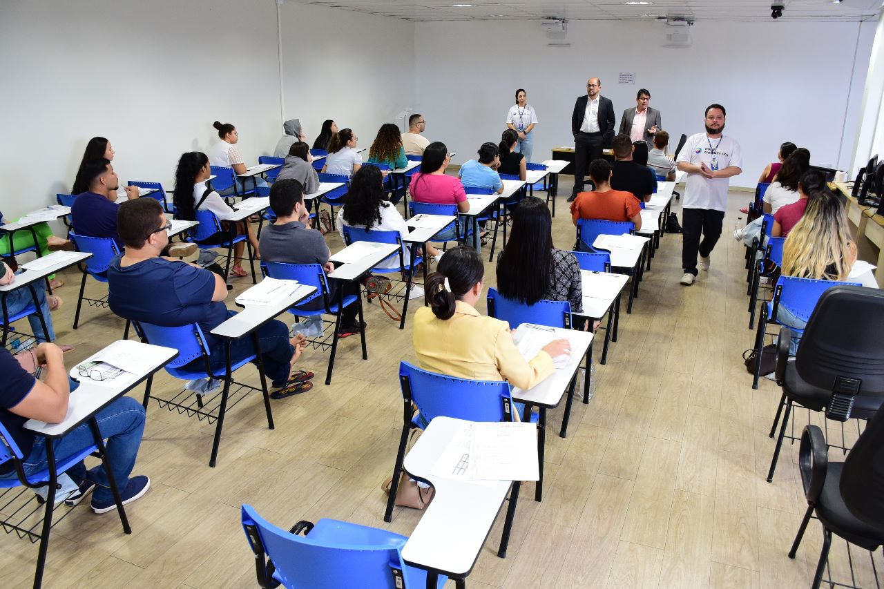 foto colorida do interior de uma sala de aula com alunos sentados 