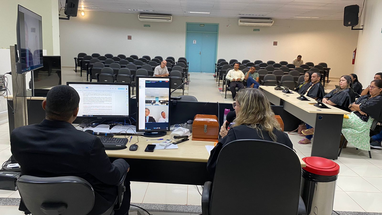 FOTO COLORIDA MOSTRANDO A JUIZA E O AUXILIAR AO LADO EM VIDEO CONFERENCIA REALIZANDO O JURI POPULAR