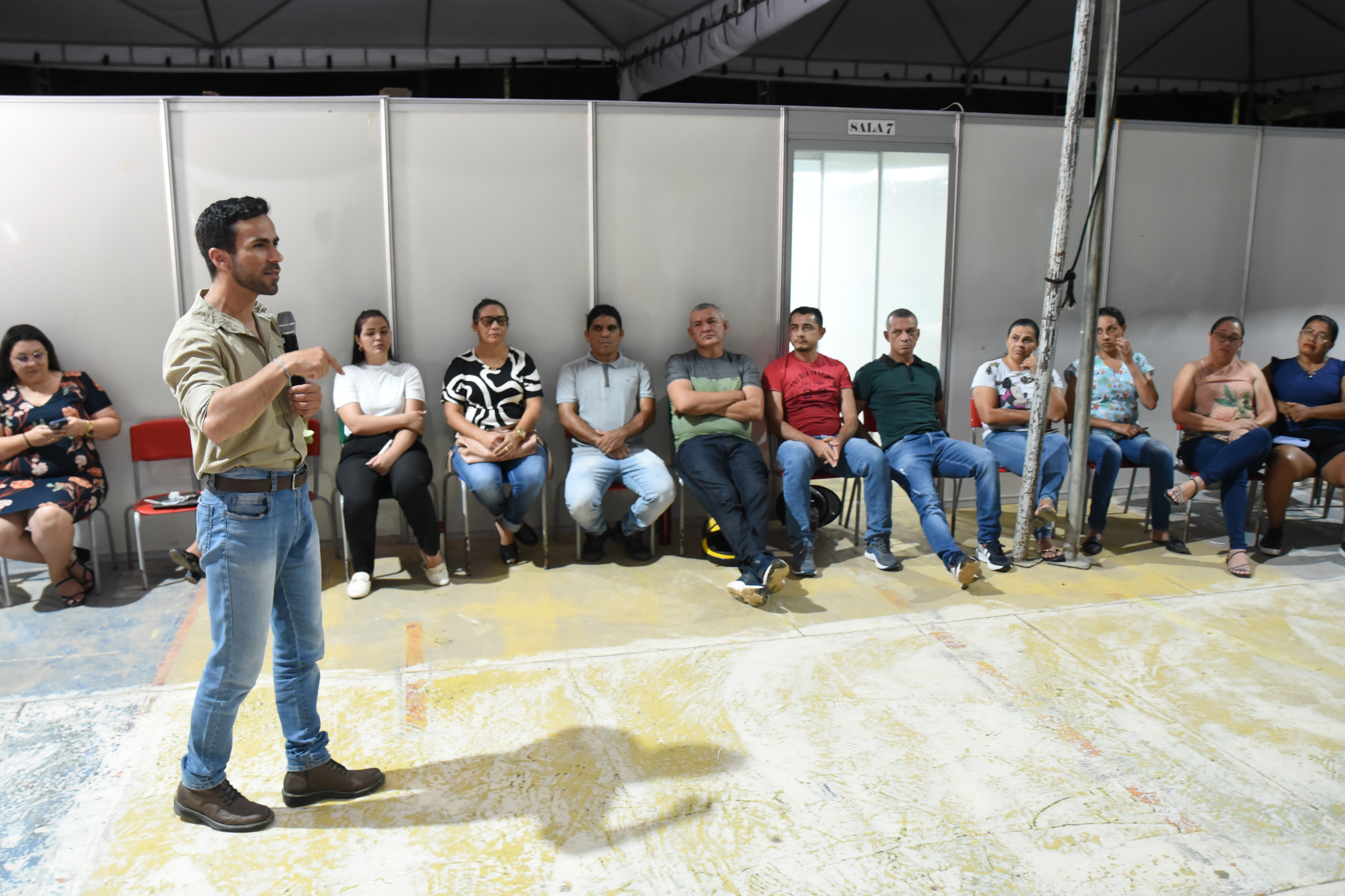 foto colorida do pedagogo Fernando Alves, do Superior Tribunal de Justiça (STJ) falando ao microfone e ao fundo há pessoas sentadas em cadeiras prestando atenção