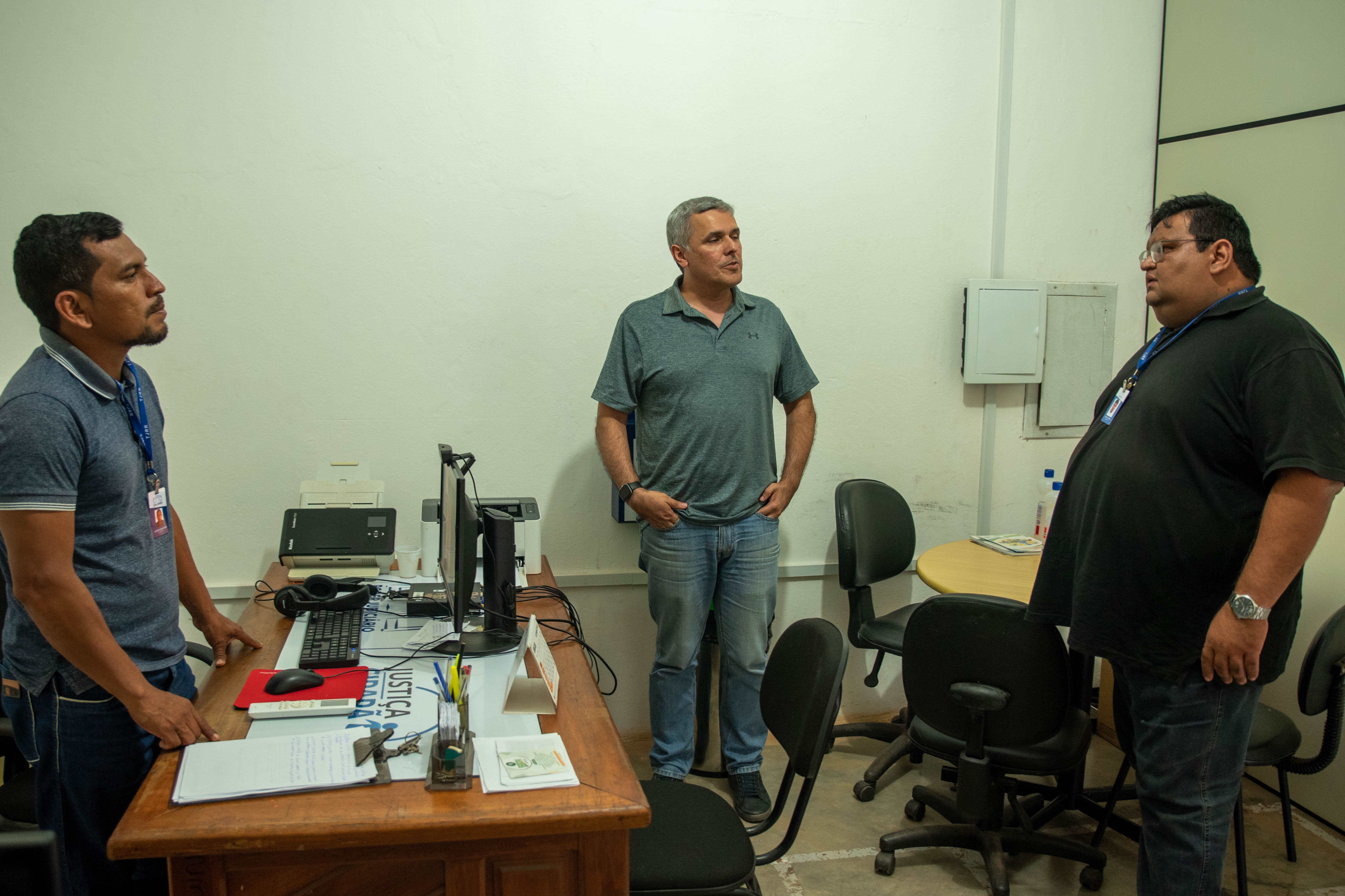 foto colorida de 3 servidores em pé em uma sala