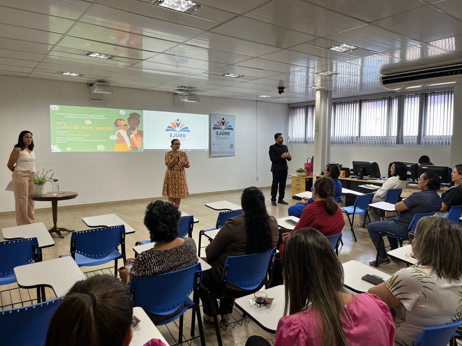 Foto colorida de diversas mulheres reunidas em uma sala.