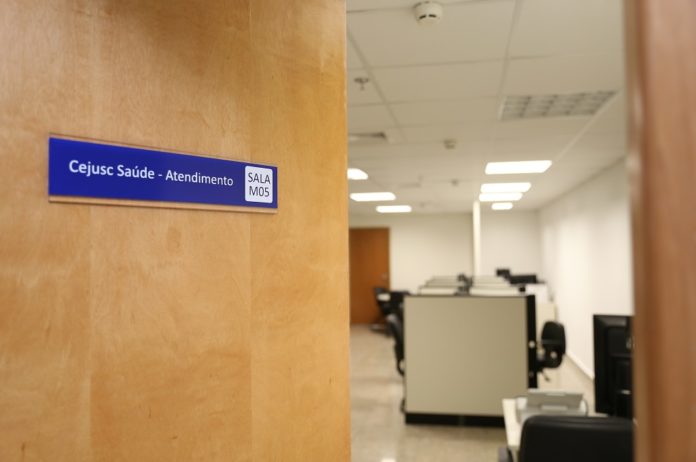 foto colorida da prota entre aberta de uma sala , na porta ta escrito  "Cejusc Saúde - Atendimento"