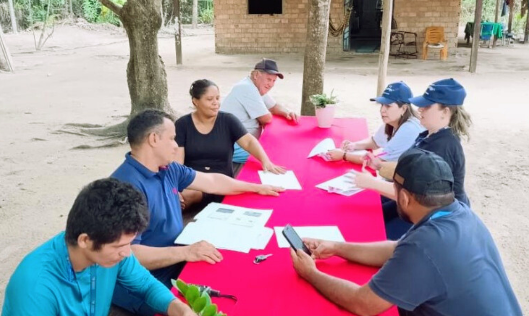 Foto colorida mostranod servidores sentados a mesa durante reunião