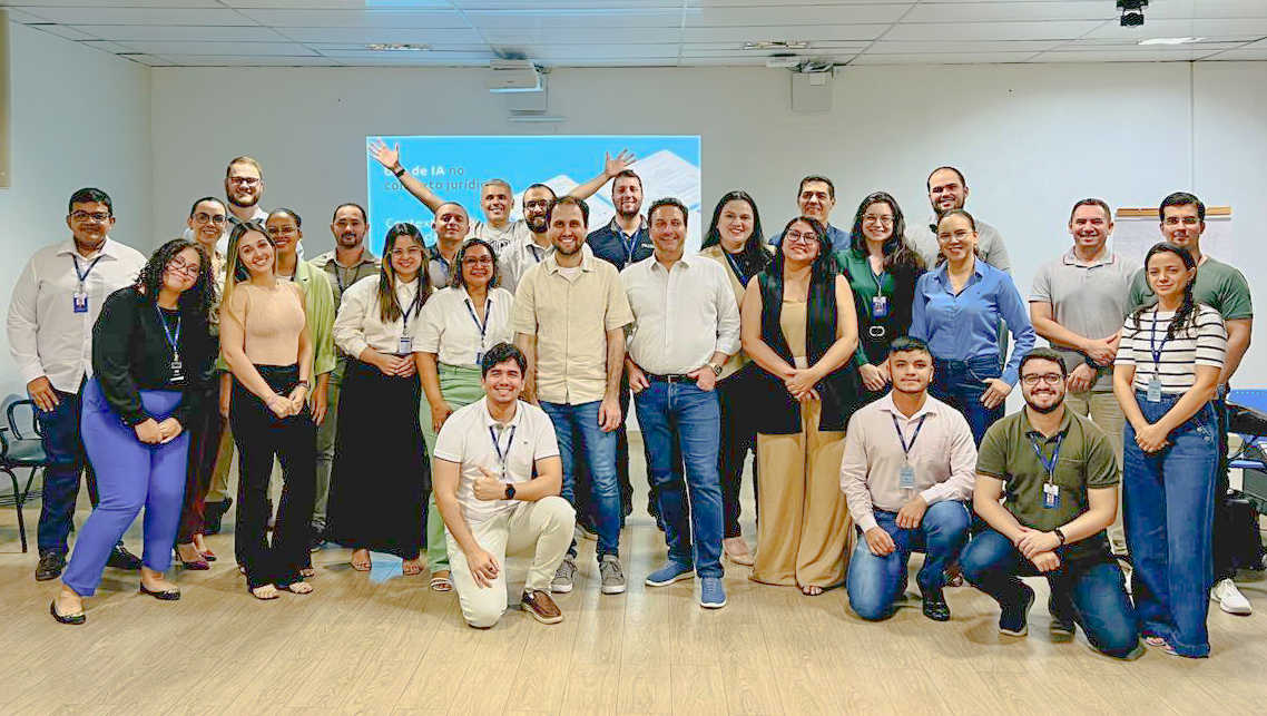 Imagem colorida mostrando pessoas posando para foto em uma sala após finalização do curso.
