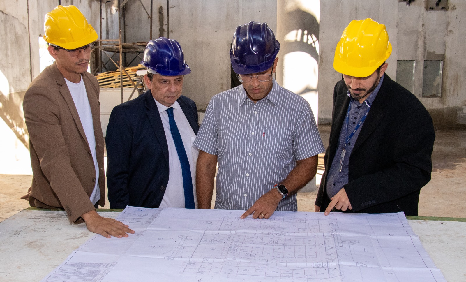 A imagem colorida mostra o presidente do TJRR, Jésus Nascimento, avaliando planta da obra do Fórum da Cidadania, com o prefeito de Boa Vista, Arthur Henrique, o secretário-geral, Henrique Tavares e com o secretário de Infraestrutura e Logística do TJRR, Reubens Mariz.