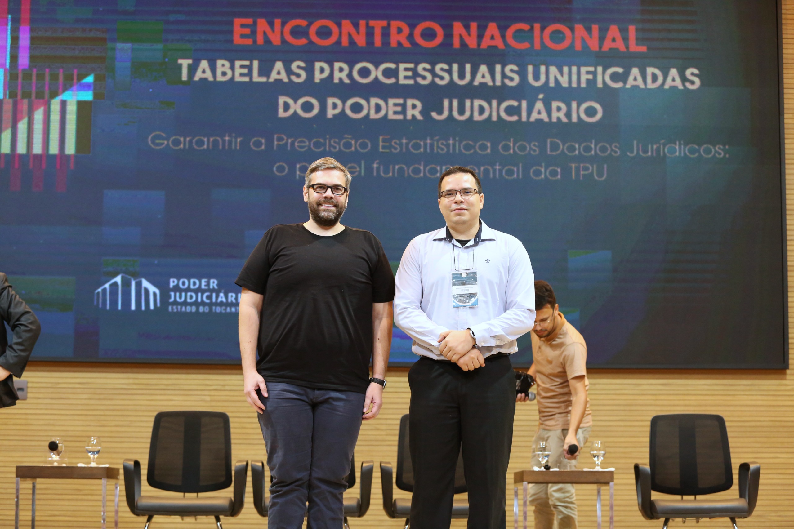 foto colorida mostradno O subsecretário de dados, Paulo Adriano e o subsecretário de governança, Arthur Azevedo, em pé posando para foto