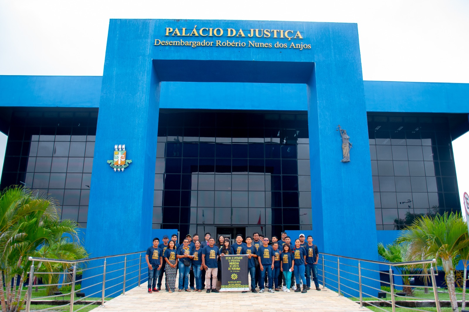 Imagem colorida mostando pessoas posando para foto em frente a entrada do Palácio da Justiça