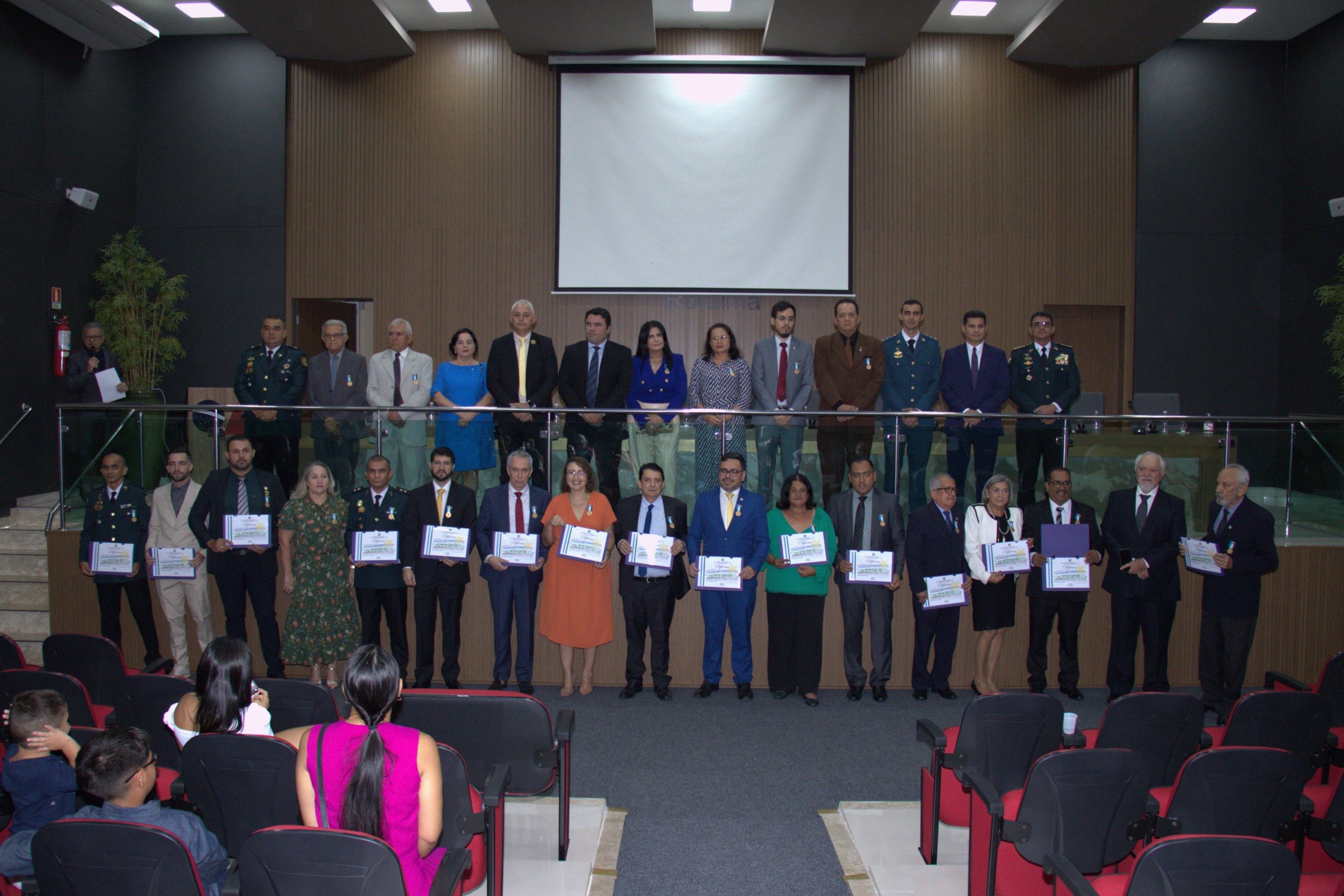 Imagem coloridam mostrando pessoas posando para foto durante entrega de homenagem. Na foto o presidente do TJRR, desembargador Jésus Nascimento, o desembargador Almiro Padilha e os juizes Daniel Damasceno e a juiza Lana Leitão