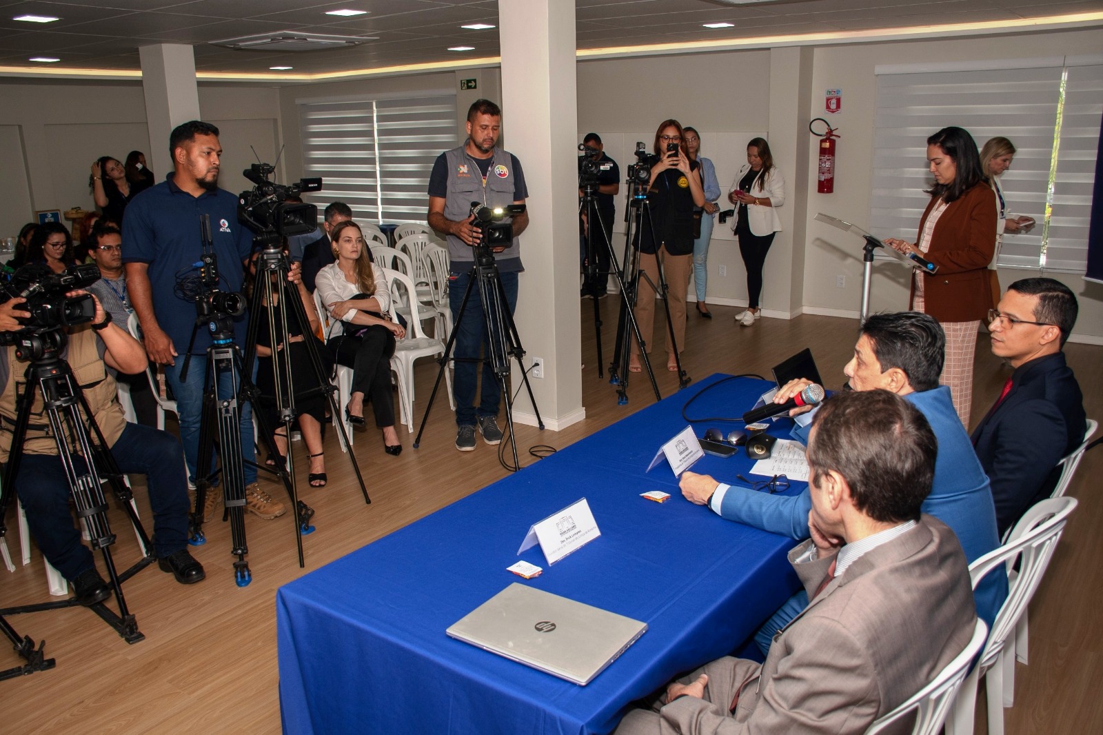 Imagem colorida mostrando presidente do TJRR, desembargador Jésus Nascimento, ao lado do desembargador Erick Linhares e o secretário Geral, Henrique Tavares, durante coletiva de imprensa. No fundo há câmeras de TV e pessoas filmando