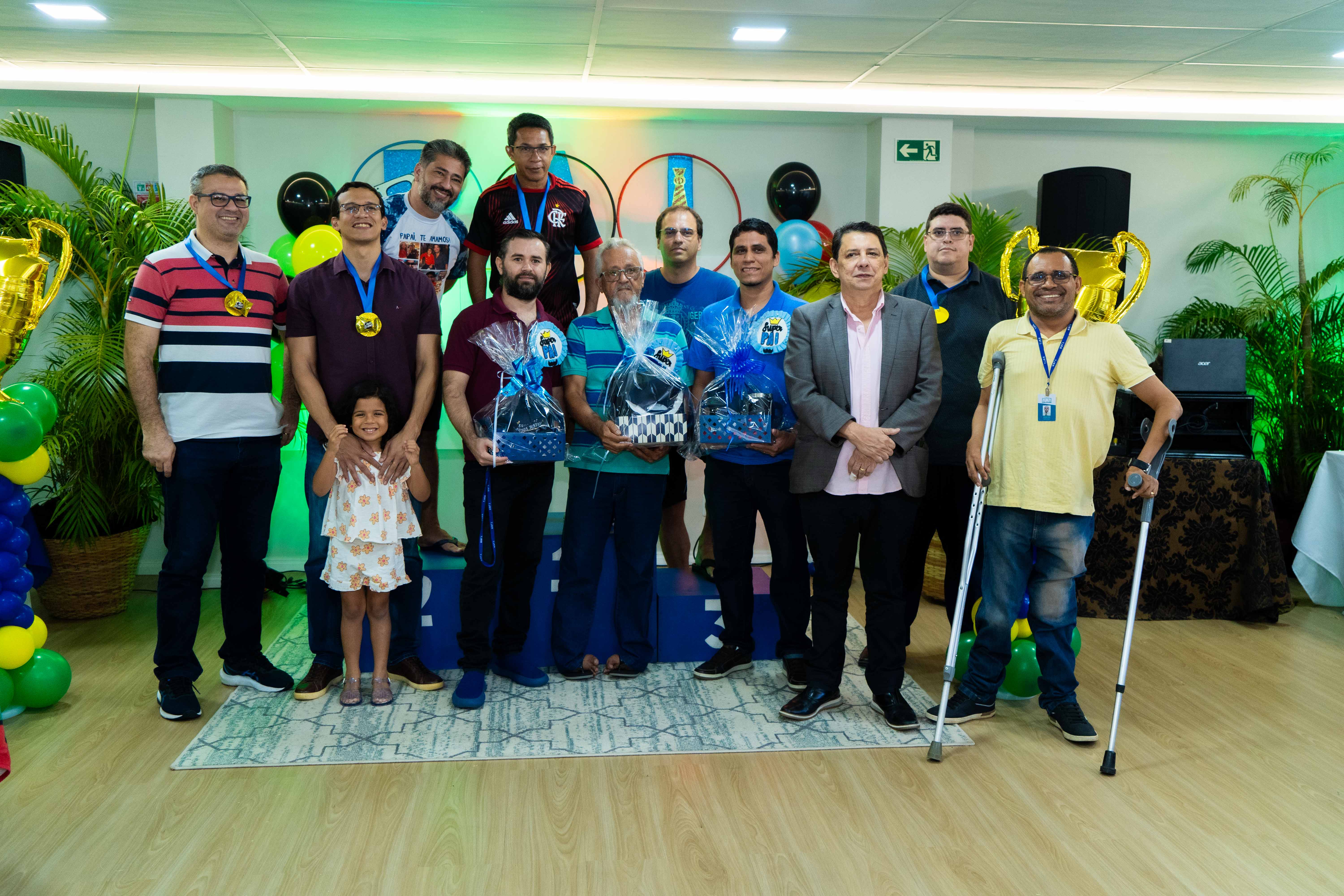 foto colorida com o presidente do TJRR, Jésus Nascimento, pousando para fotografia ao lado de outros servidores. Todos eles tem uma medalha no pescoço