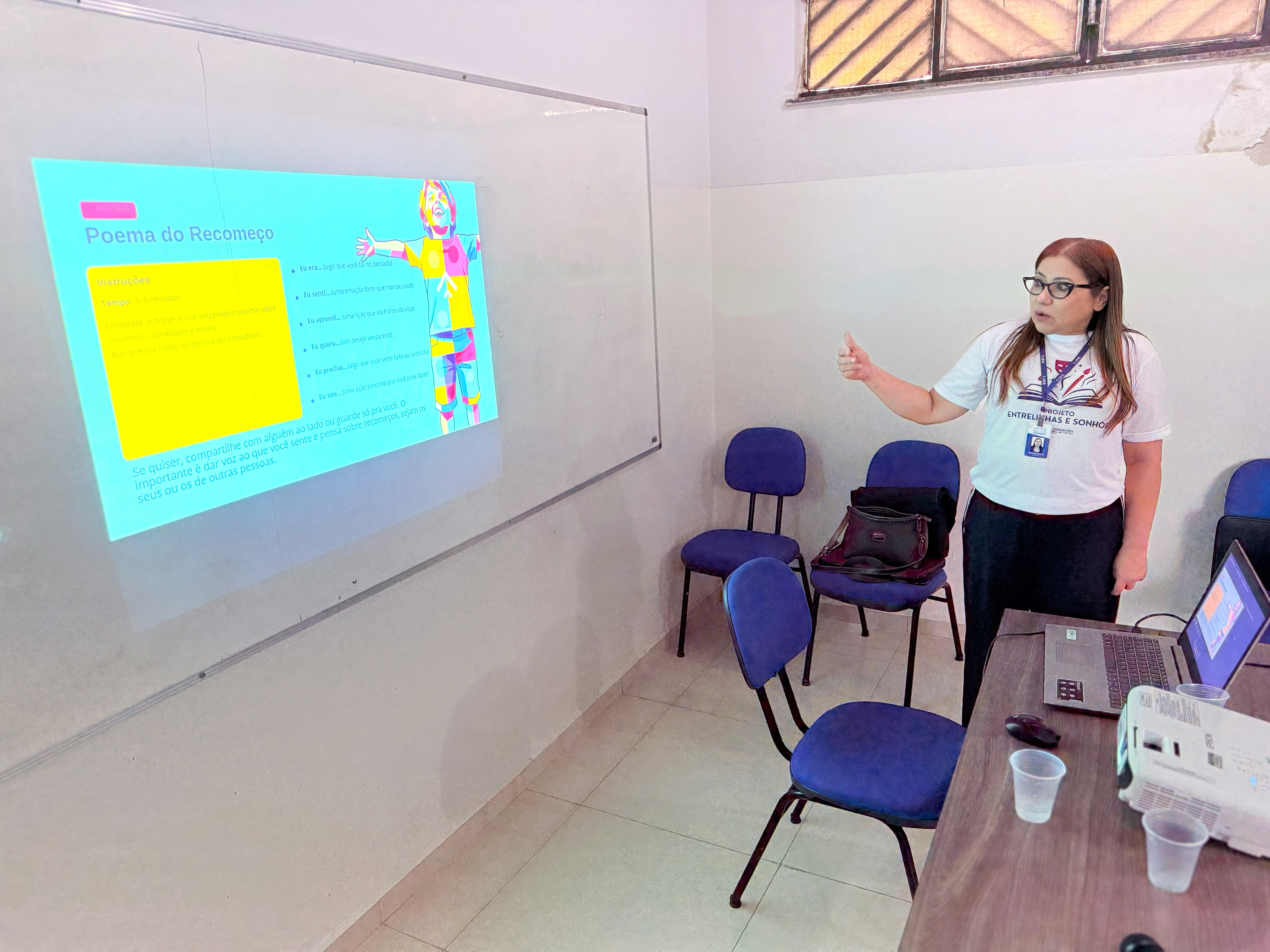 Integrante do projeto apresenta, com apoio de material projetado, uma das atividades do primeiro encontro do Entrelinhas e Sonhos, que propõe o uso da arte e da cultura como caminhos de expressão, reflexão e construção de novos sentidos. Integrante do projeto apresenta, com apoio de material projetado, uma das atividades do primeiro encontro do Entrelinhas e Sonhos, que propõe o uso da arte e da cultura como caminhos de expressão, reflexão e construção de novos sentidos.