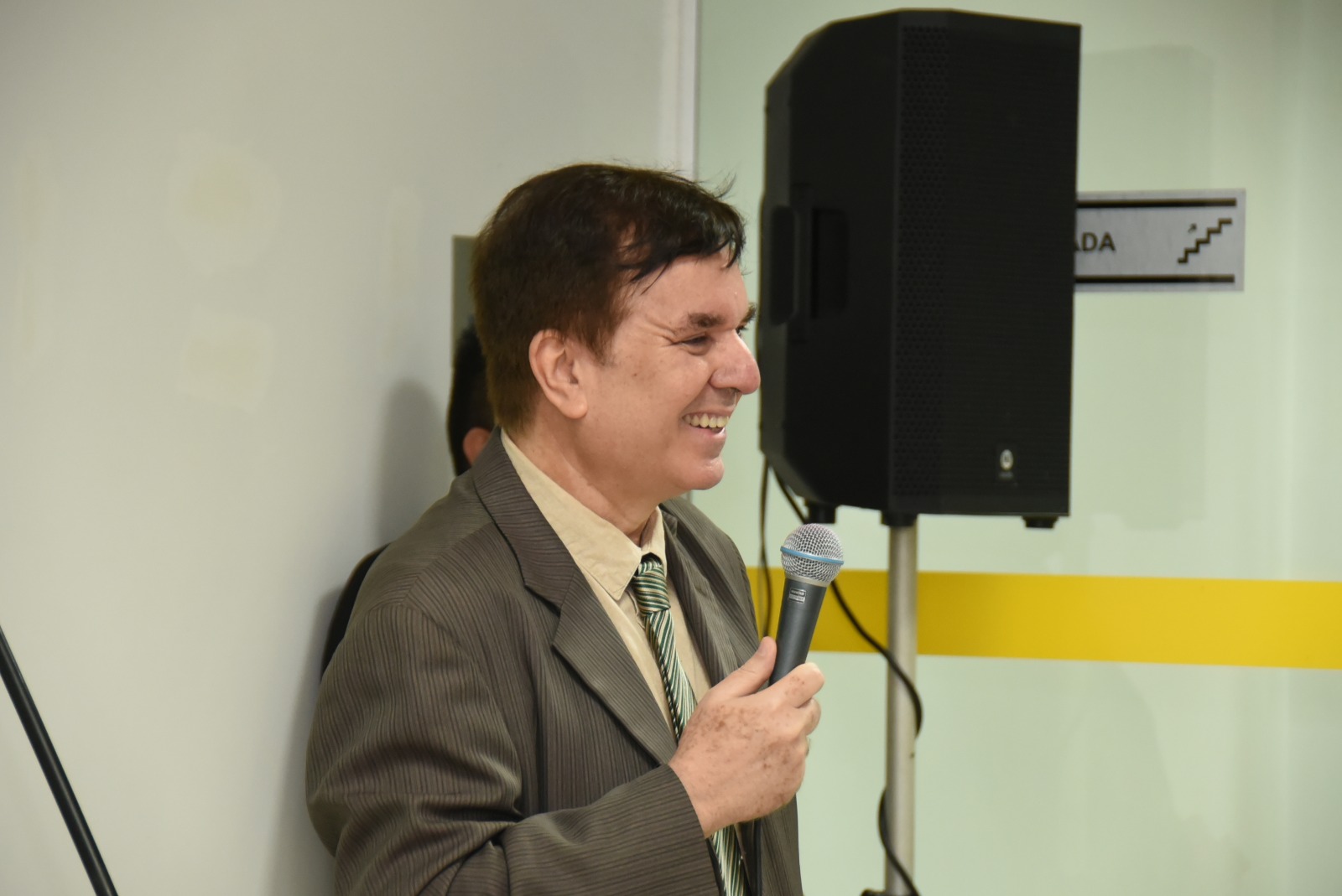  o juiz titular da Vara de Execuções de Penas e Medidas Alternativas (VEPEMA), Alexandre Magno, falando ao microfone enquanto os convidados estão sentados