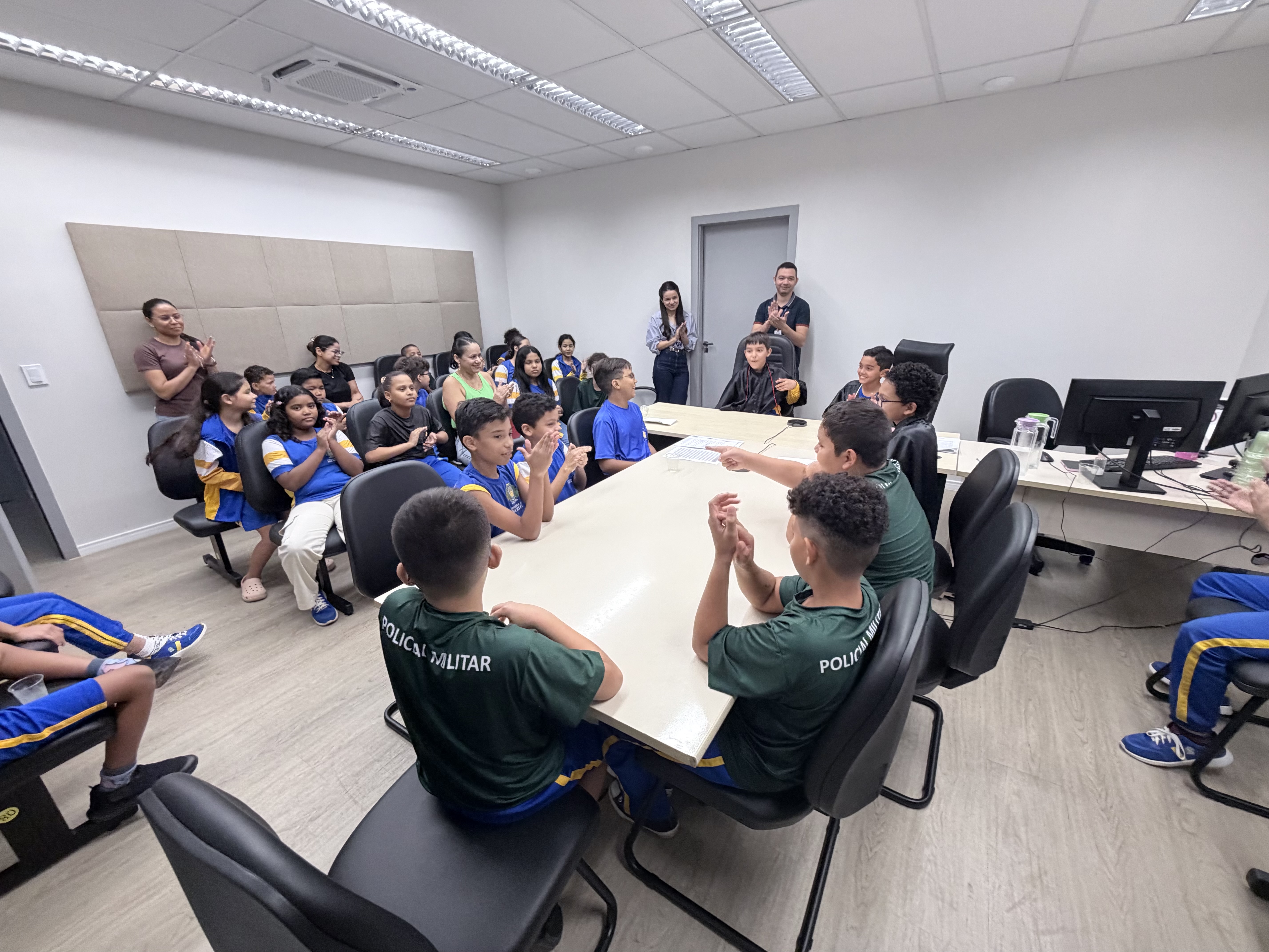 Vista colorida mostra o juiz e coordenador da CIJ/TJRR, Marcelo Oliveira durante audiência simulada com crianças da Escola Municipal Maria Teresa Maciel.