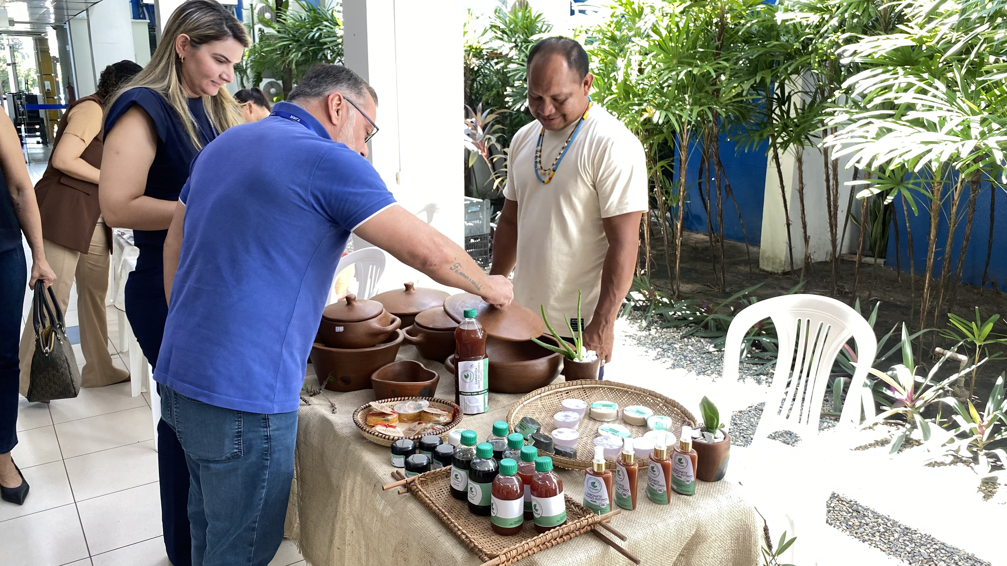 homem comprando uma panela de barro durante a feira.Na mesa também contém produtos naturais. homem comprando uma panela de barro durante a feira.Na mesa também contém produtos naturais.