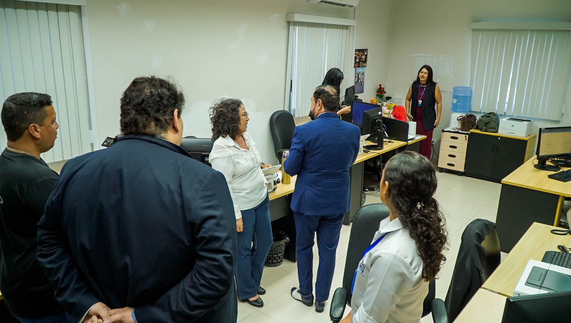 Imagem colorida mostra  o desembargador presidente do TJRR, Leonardo Cupello, cumprimentando uma servidora durante a passagem pelas dependências da unidade. Outros integrantes da equipe acompanham o encontro.