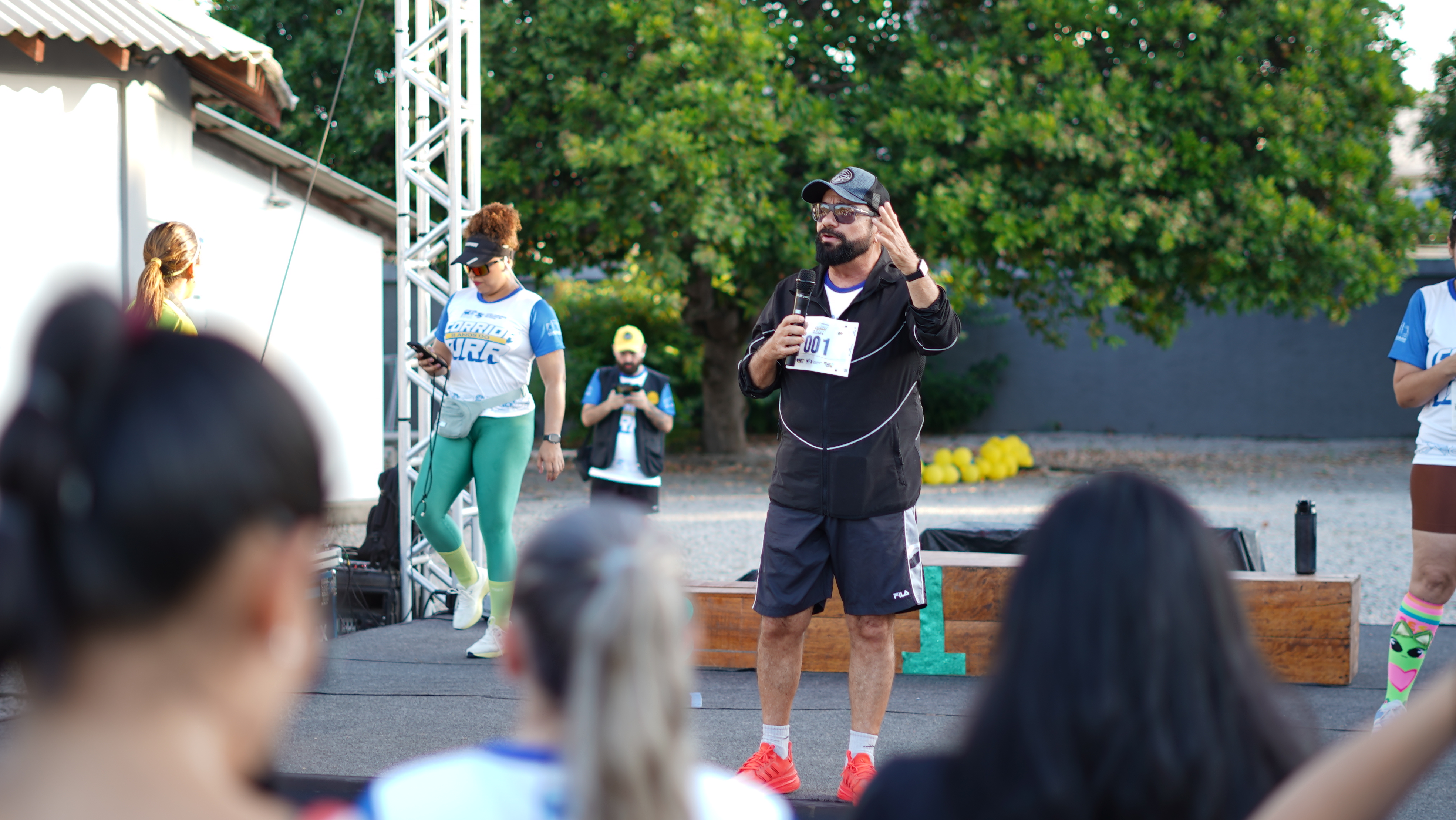 Imagem colorida mostra o presidente do TJRR, desembargador Leonardo Cupello, vestindo roupa esportiva e número de peito, falando ao microfone antes da corrida. Ele gesticula diante dos participantes reunidos em frente ao palco. Imagem colorida mostra o presidente do TJRR, desembargador Leonardo Cupello, vestindo roupa esportiva e número de peito, falando ao microfone antes da corrida. Ele gesticula diante dos participantes reunidos em frente ao palco.