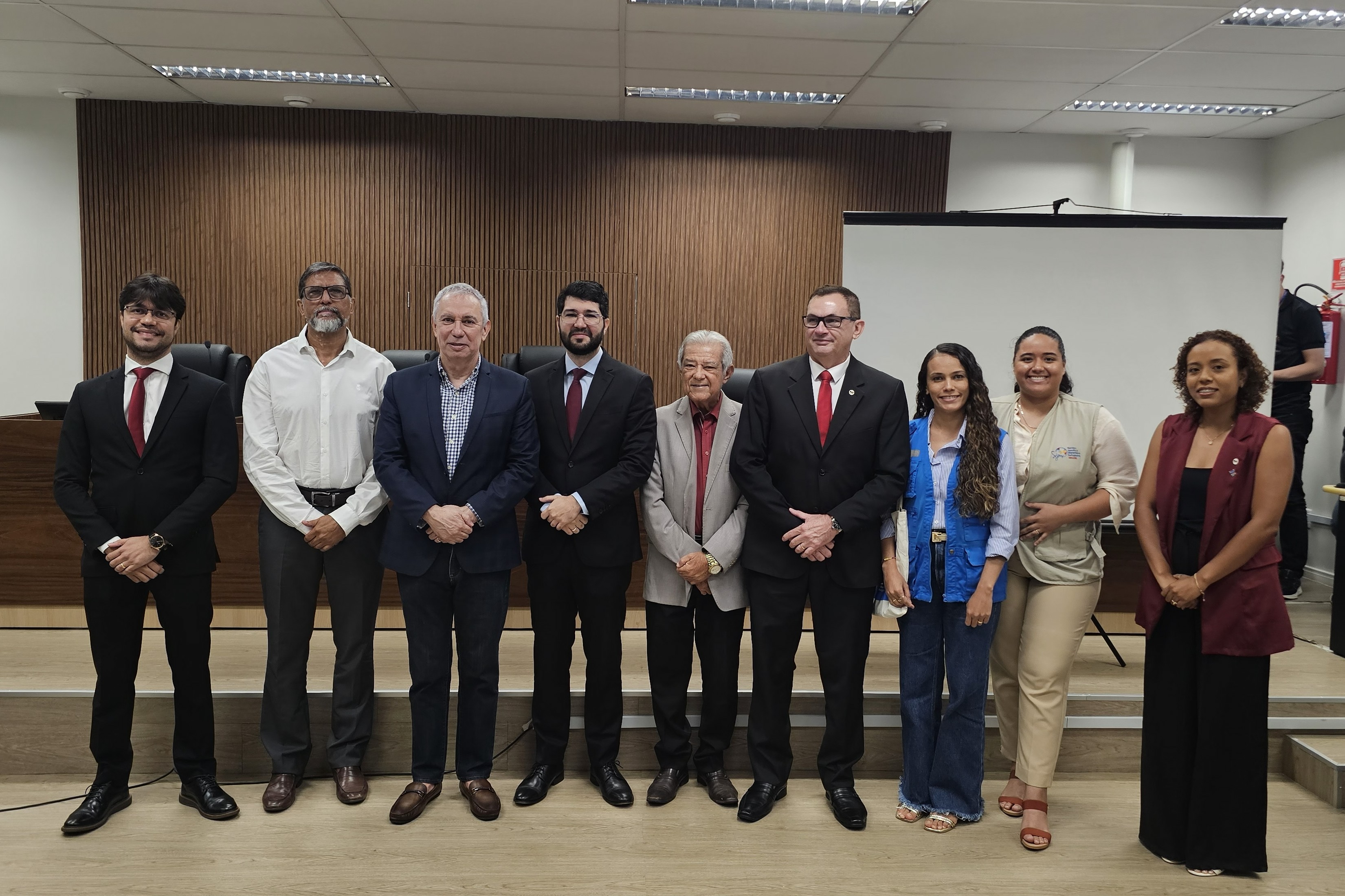 Imagem colorida mostra representantes do Tribunal de Justiça de Roraima e de instituições parceiras posando para uma fotografia coletiva após a apresentação dos resultados da III Ação Sociojurídica. O grupo está reunido à frente da bancada do auditório. Imagem colorida mostra representantes do Tribunal de Justiça de Roraima e de instituições parceiras posando para uma fotografia coletiva após a apresentação dos resultados da III Ação Sociojurídica. O grupo está reunido à frente da bancada do auditório.
