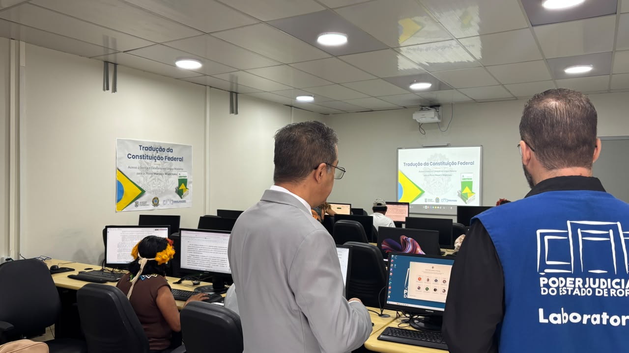 Em primeiro plano contem dois servidores do TJRR em pé e ao fundo é possível ver os tradutores mexendo no computador Em primeiro plano contem dois servidores do TJRR em pé e ao fundo é possível ver os tradutores mexendo no computador