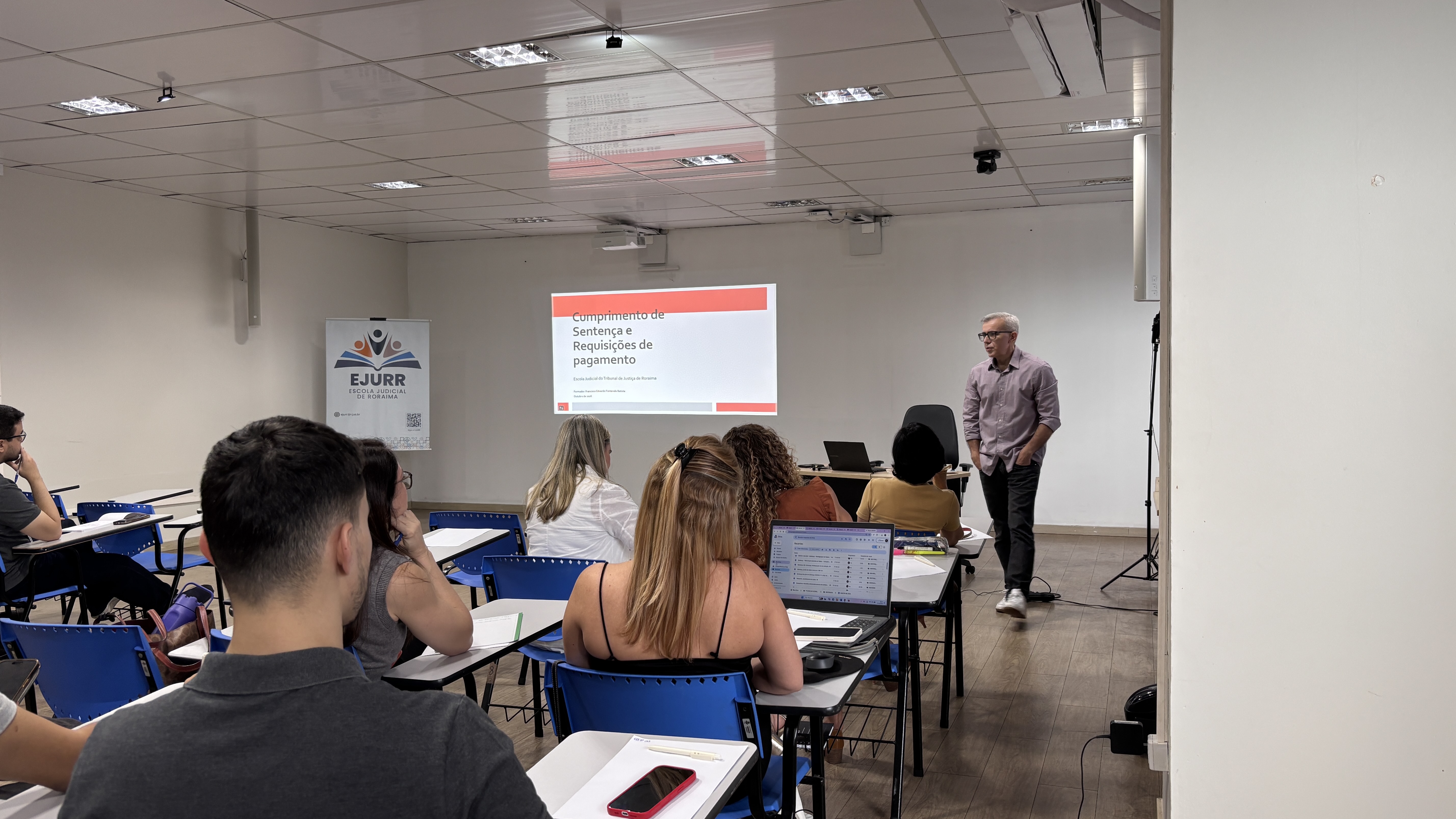 imagem mais fechada mostrando pessoas na sala de aula com uma pessoa apresentando. imagem mais fechada mostrando pessoas na sala de aula com uma pessoa apresentando.