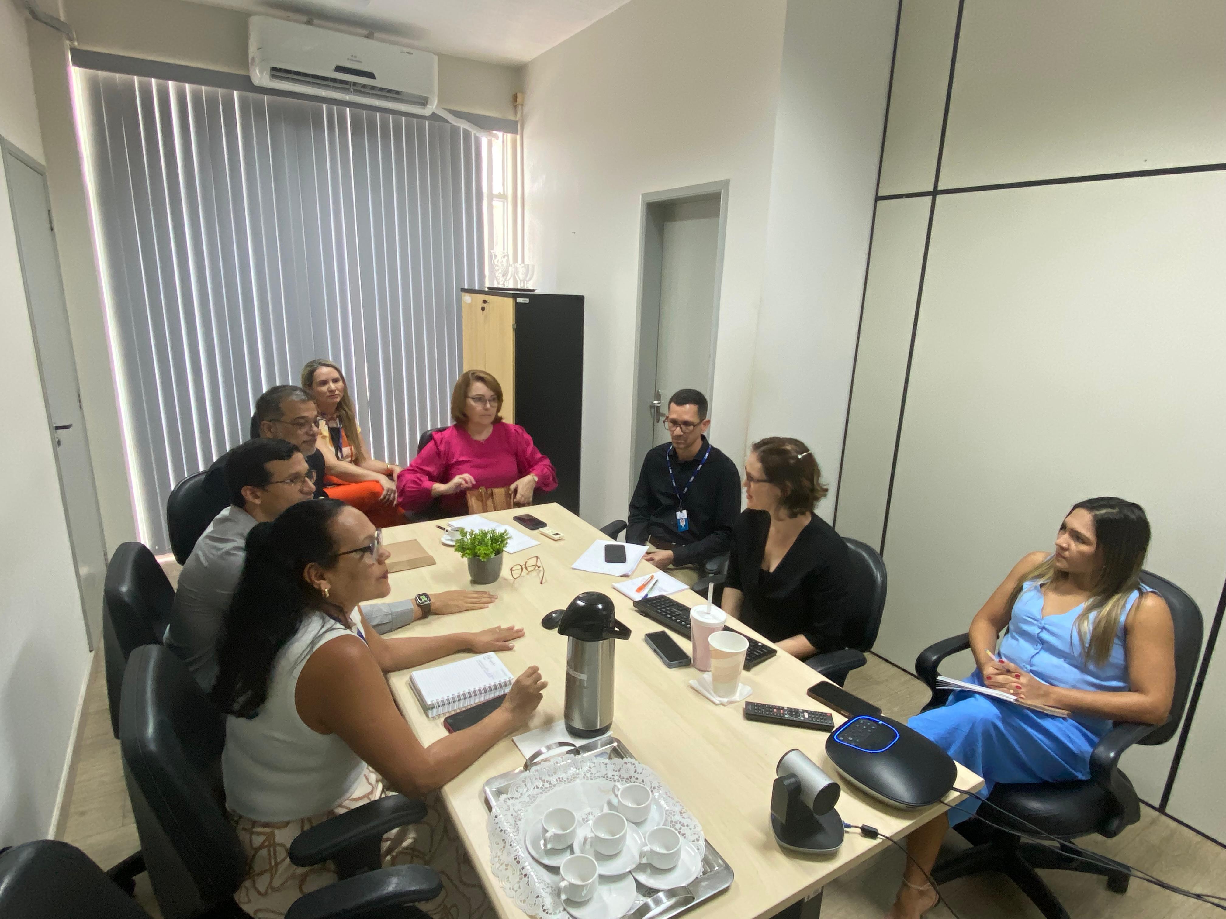 Imagem colorida contém oito pessoas, sendo Magistradas, Secretários, Secretária e servidores do TJRR, durante a primeira reunião da Comissão de Sustentabilidade do Tribunal de Justiça de Roraima. Na imagem encontra-se a Presidente da Comissão, Desembargadora e Ouvidora-Geral do TJRR, Elaine Bianchi, a Coordenadora Paloma Lima de Souza Cruz, Chefe do Setor de Sustentabilidade e Responsabilidade Social, da participação de Hermenegildo Ataíde D'Ávila, Secretário-Geral; Boniek Amurim de Souza, assessor técnico da Secretaria de Tecnologia da Informação; Henrique de Melo Tavares, Secretário de Gestão Administrativa; Érika Horta, Subsecretária de Processos e Gestão da Qualidade; Klíssia Michelle Melo Oliveira, Gerente de Projetos; Nádia Janaína de Souza, assistente técnica da Ouvidoria-Geral de Justiça; a Secretária de Gestão Estratégica, Veruska Lobo, e Gilvanildo Moura, chefe da Central de Mandados.Todos encontram-se em voltas de uma mesa de reunião. Imagem colorida contém oito pessoas, sendo Magistradas, Secretários, Secretária e servidores do TJRR, durante a primeira reunião da Comissão de Sustentabilidade do Tribunal de Justiça de Roraima. Na imagem encontra-se a Presidente da Comissão, Desembargadora e Ouvidora-Geral do TJRR, Elaine Bianchi, a Coordenadora Paloma Lima de Souza Cruz, Chefe do Setor de Sustentabilidade e Responsabilidade Social, da participação de Hermenegildo Ataíde D'Ávila, Secretário-Geral; Boniek Amurim de Souza, assessor técnico da Secretaria de Tecnologia da Informação; Henrique de Melo Tavares, Secretário de Gestão Administrativa; Érika Horta, Subsecretária de Processos e Gestão da Qualidade; Klíssia Michelle Melo Oliveira, Gerente de Projetos; Nádia Janaína de Souza, assistente técnica da Ouvidoria-Geral de Justiça; a Secretária de Gestão Estratégica, Veruska Lobo, e Gilvanildo Moura, chefe da Central de Mandados.Todos encontram-se em voltas de uma mesa de reunião.
