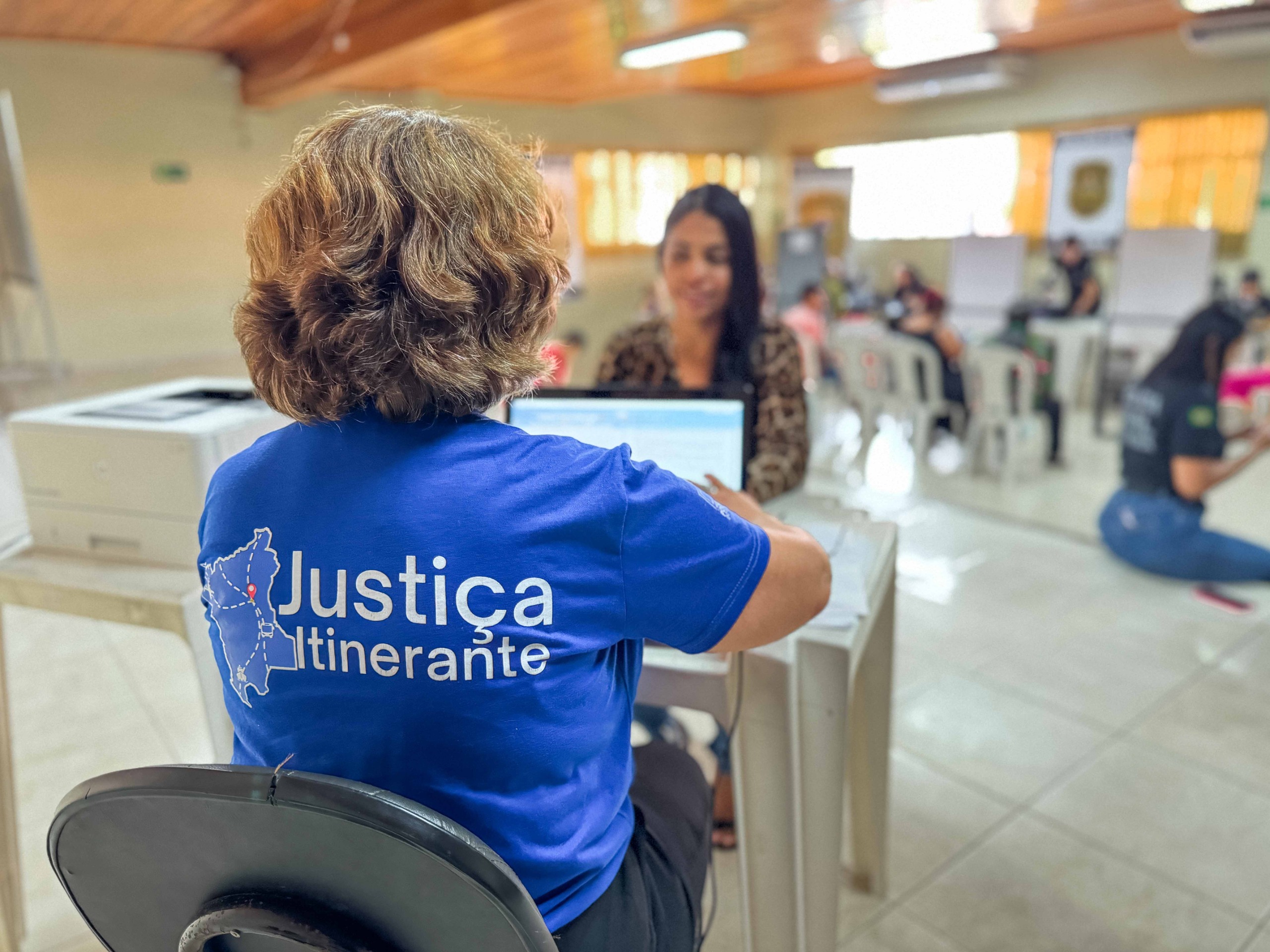 Imagem colorida mostra uma servidora da Vara da Justiça Itinerante do TJRR atendendo uma cidadã durante a ação “Saúde de Rua”, realizada pelo Sesi Roraima.