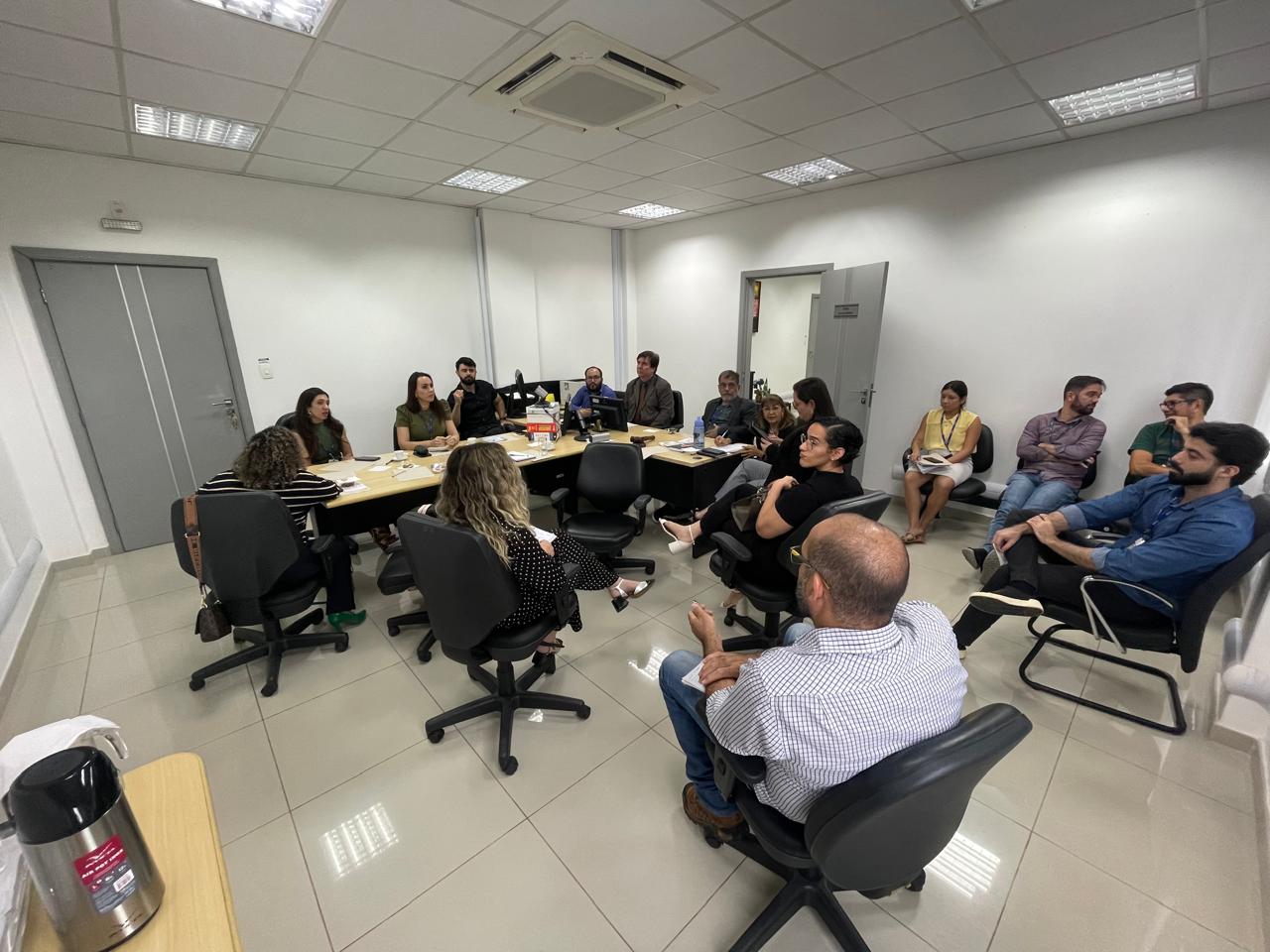 Imagem colorida contendo 16 servidores do TJRR e representantes que atuam com a VEPEMA, reunidos em torno de uma mesa durante a reunião bienal da VEPEMA. 