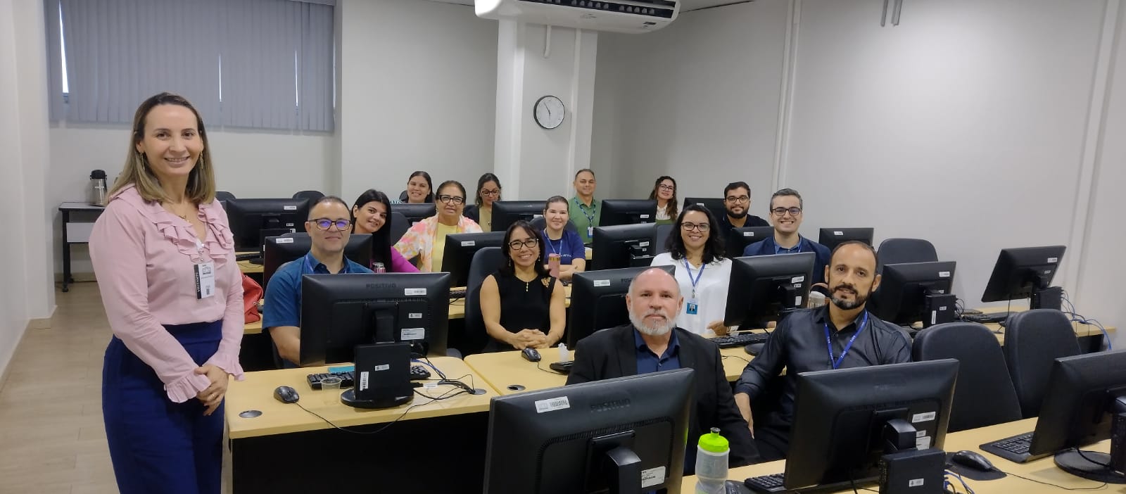 magem colorida de uma sala composta por um grupo de pessoas sentado à mesa com computadores individuais todos estão olhando em direção para a fotografia magem colorida de uma sala composta por um grupo de pessoas sentado à mesa com computadores individuais todos estão olhando em direção para a fotografia
