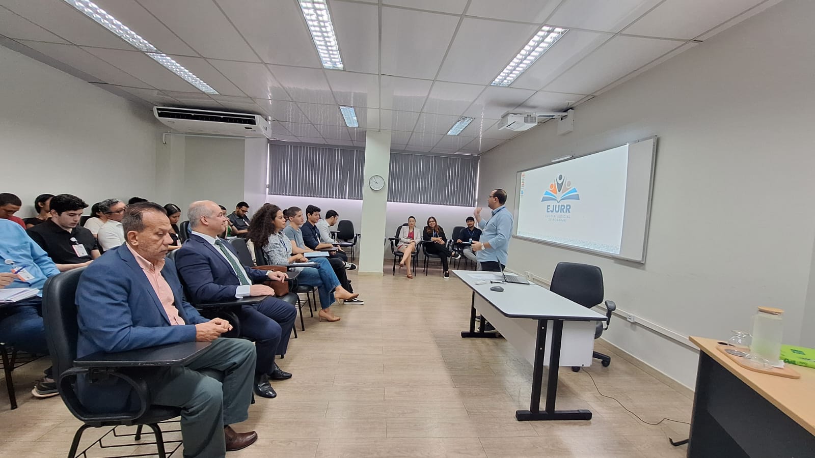 Imagem colorida de uma servidora do TJ falando para o grupo de estudantes. Imagem colorida de uma servidora do TJ falando para o grupo de estudantes.
