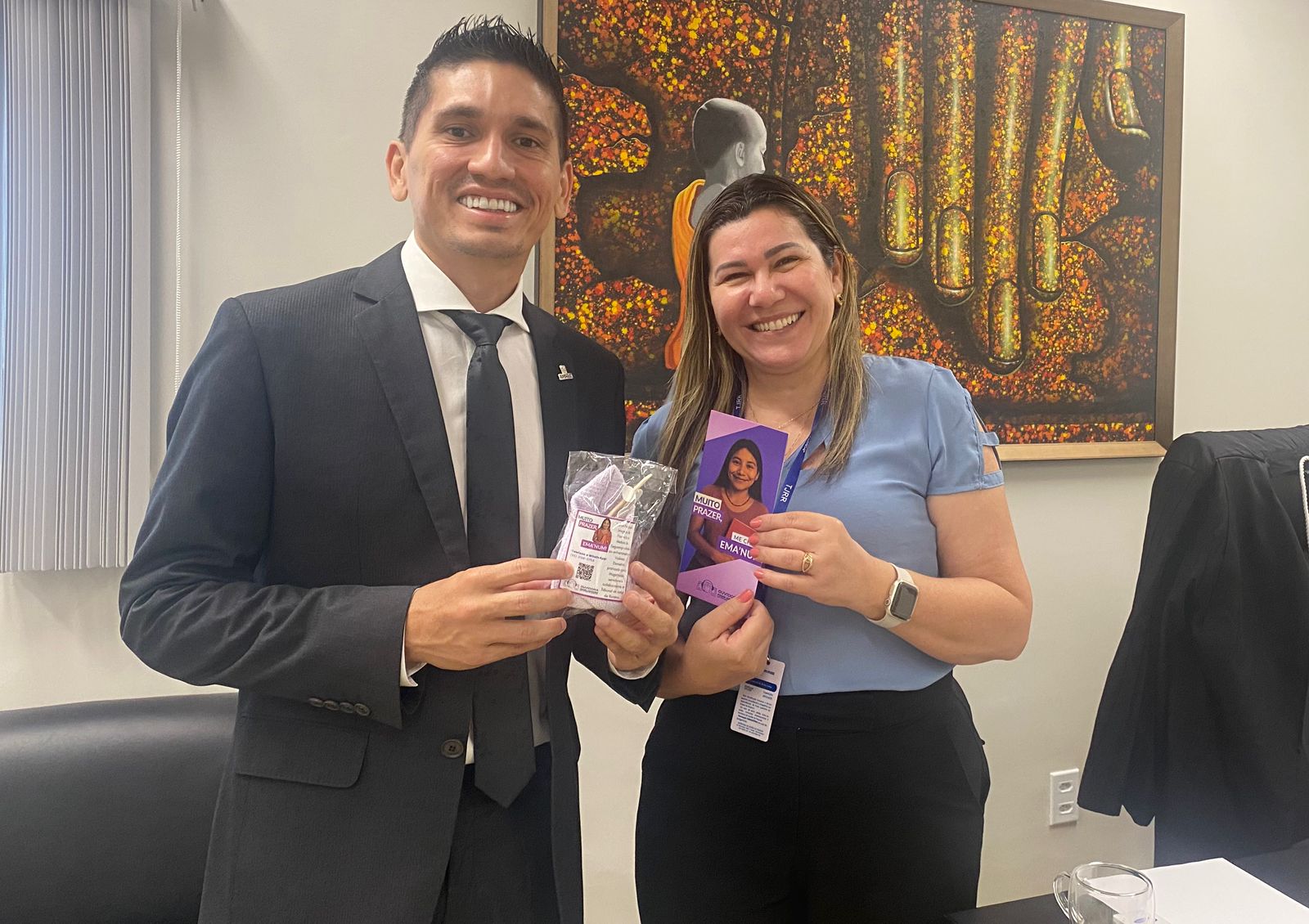 foto colorida de duas pessoas senod um homem e uma mulher pousando para fotografia segurando um papel do Emanum foto colorida de duas pessoas senod um homem e uma mulher pousando para fotografia segurando um papel do Emanum