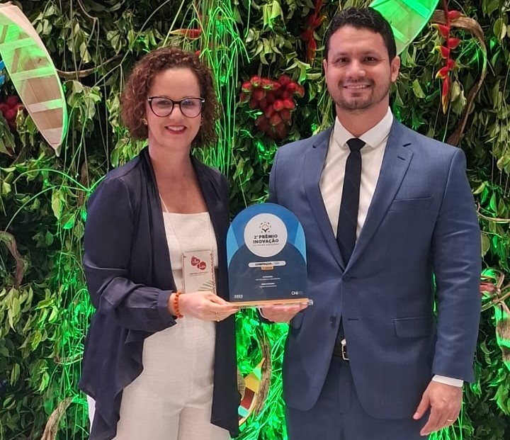 Imagem colorida do juiz de direito do Tribunal de Justiça de Roraima e laborista do laboratório de inovação, Cleber Gonçalves e a a Coordenadora do Núcleo de Projeto e Inovação (NPI), Inaiara Sá pousando para fotografia segurando a premiação. Imagem colorida do juiz de direito do Tribunal de Justiça de Roraima e laborista do laboratório de inovação, Cleber Gonçalves e a a Coordenadora do Núcleo de Projeto e Inovação (NPI), Inaiara Sá pousando para fotografia segurando a premiação.