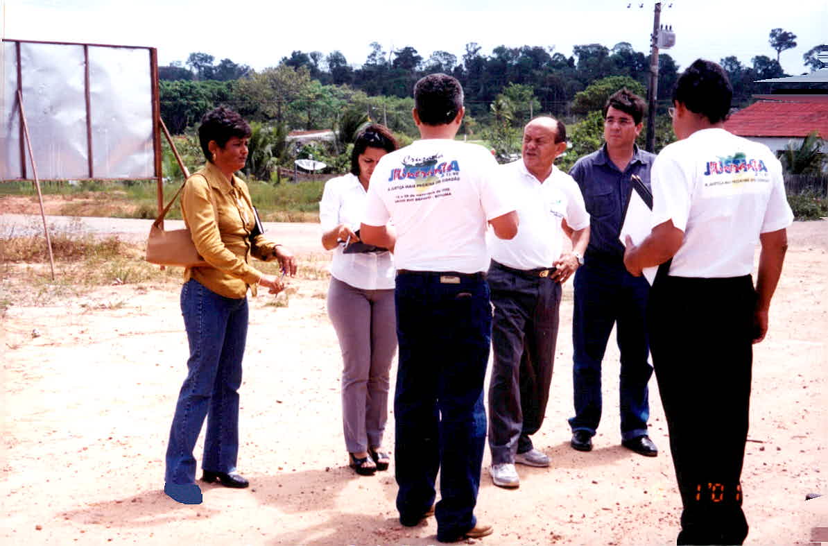  A imagem colorida contém seis pessoas, conversando durante atendimento da Cruzada da Justiça Itinerante, entre elas o desembargador Elair de Morais.